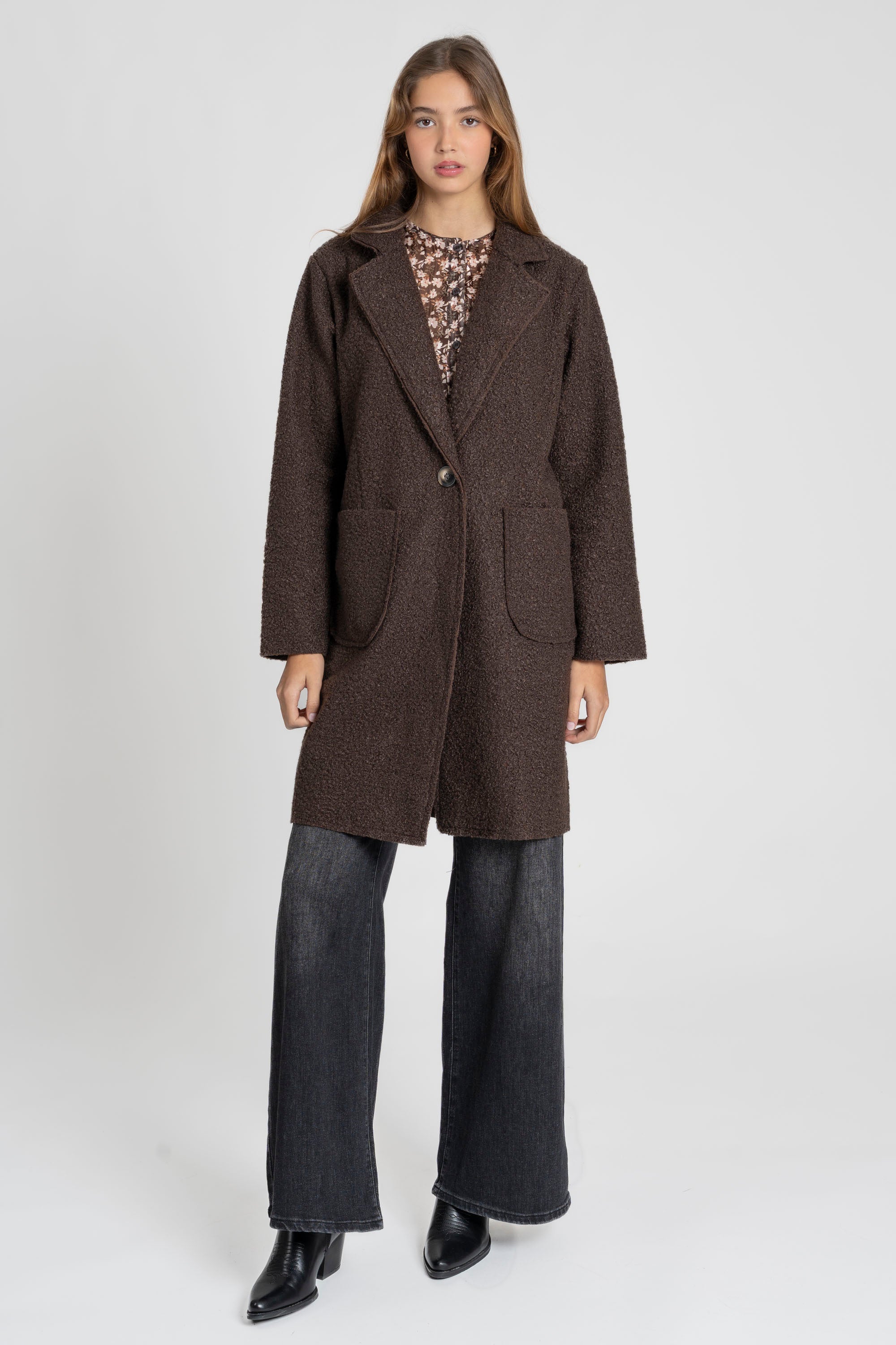 Modèle portant un manteau chaud hiver femme sherpa avec col revers et poches avant, style casual et chic.
