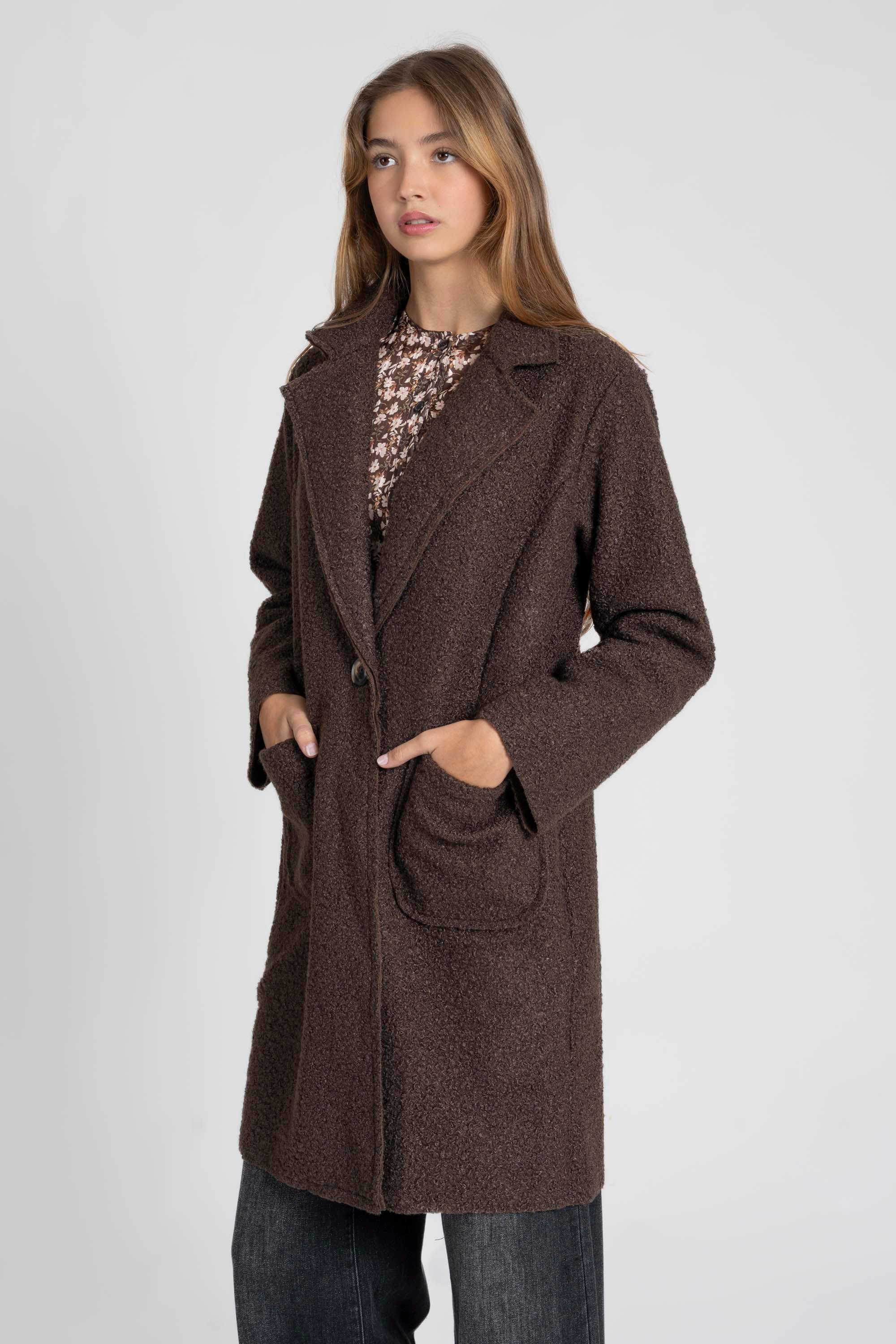 Femme posant en manteau chaud hiver femme sherpa, de couleur brun, col à revers et poches avant, pour un look élégant.