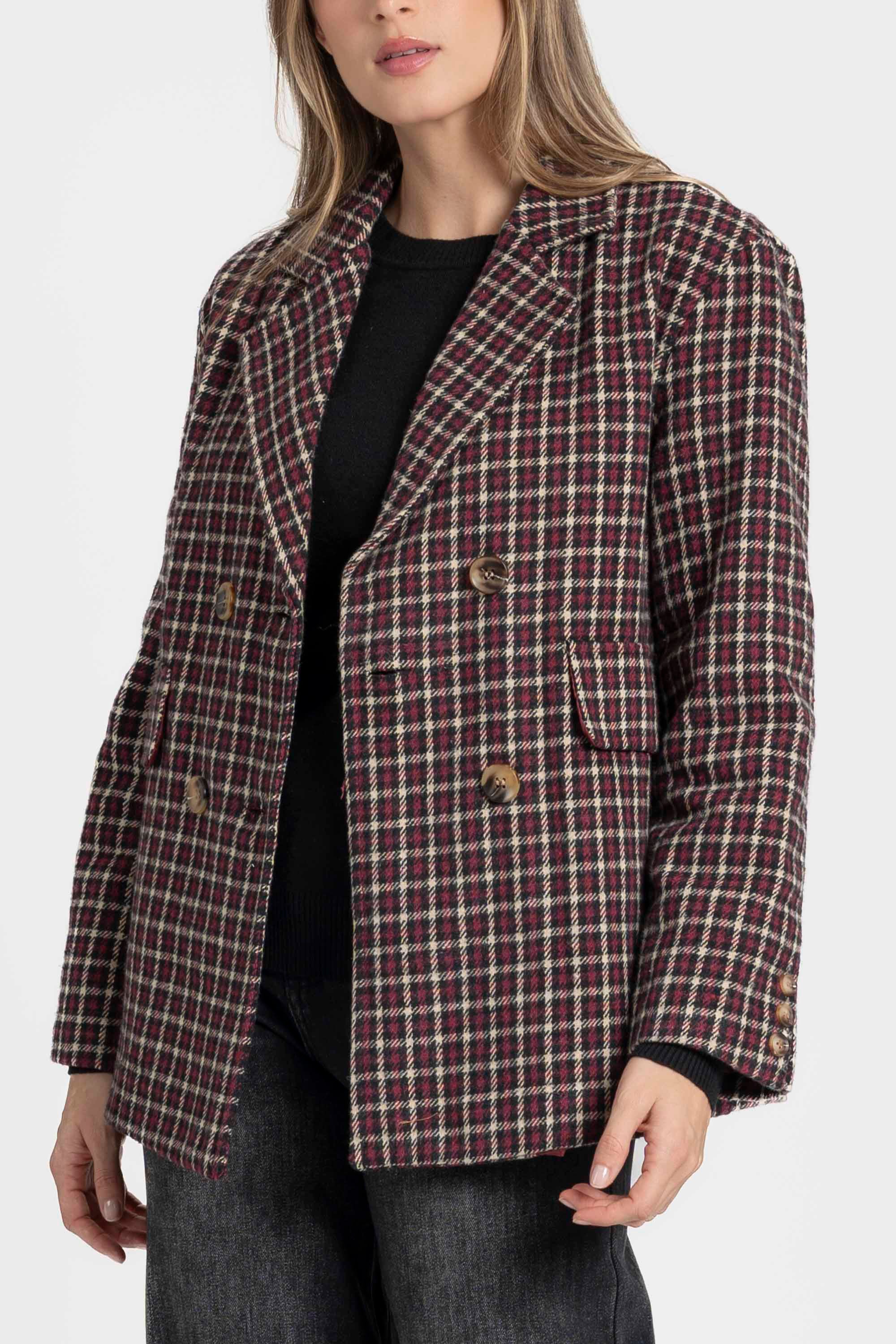 Vue détaillée d'une femme avec un blazer coton femme bordeaux et marron, coupe élégante, fermant le bouton, soulignant le style chic