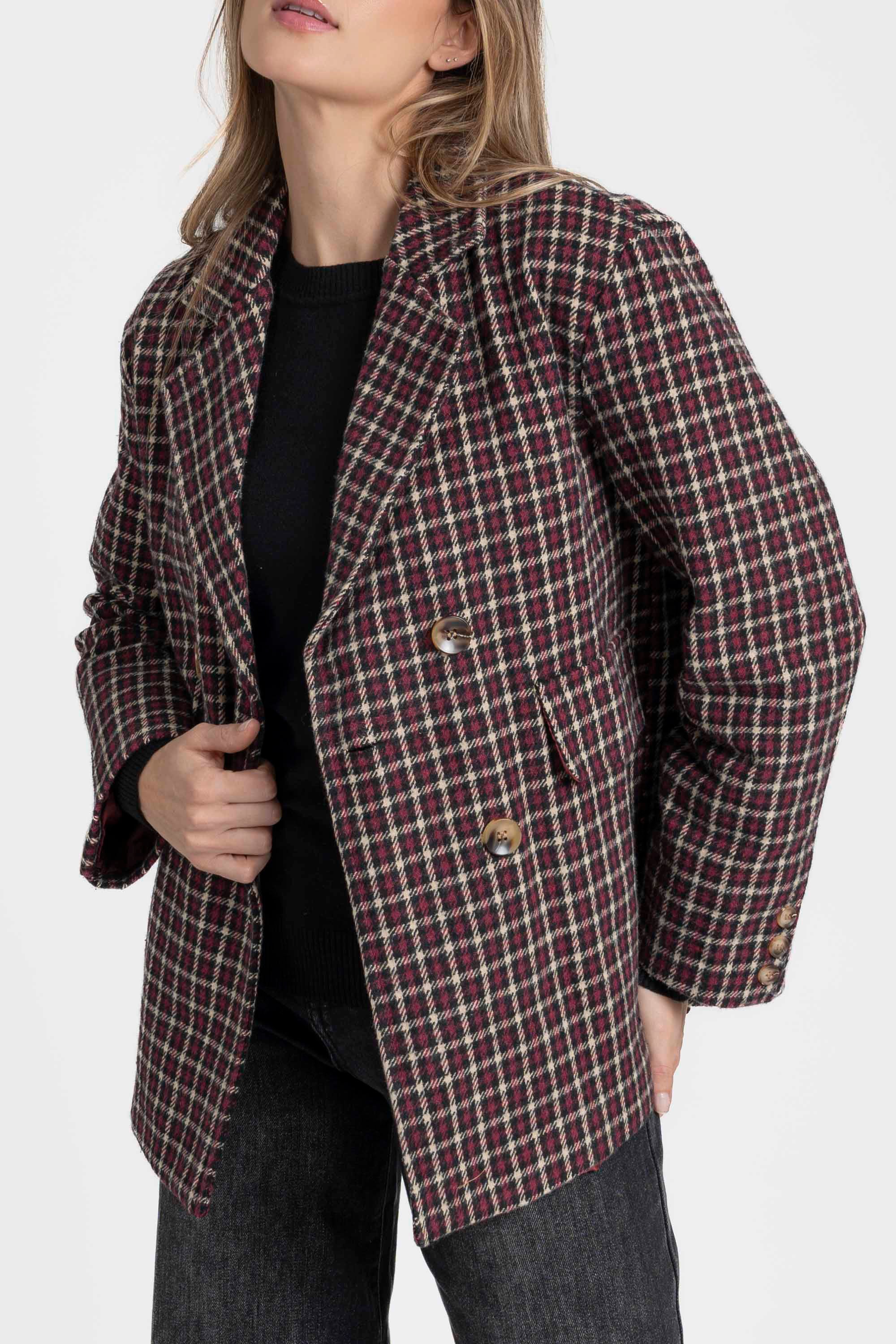 Femme avec un blazer coton femme bordeaux et marron, coupe élégante, posant avec une main sur la taille, révélant le design structuré du vêtement