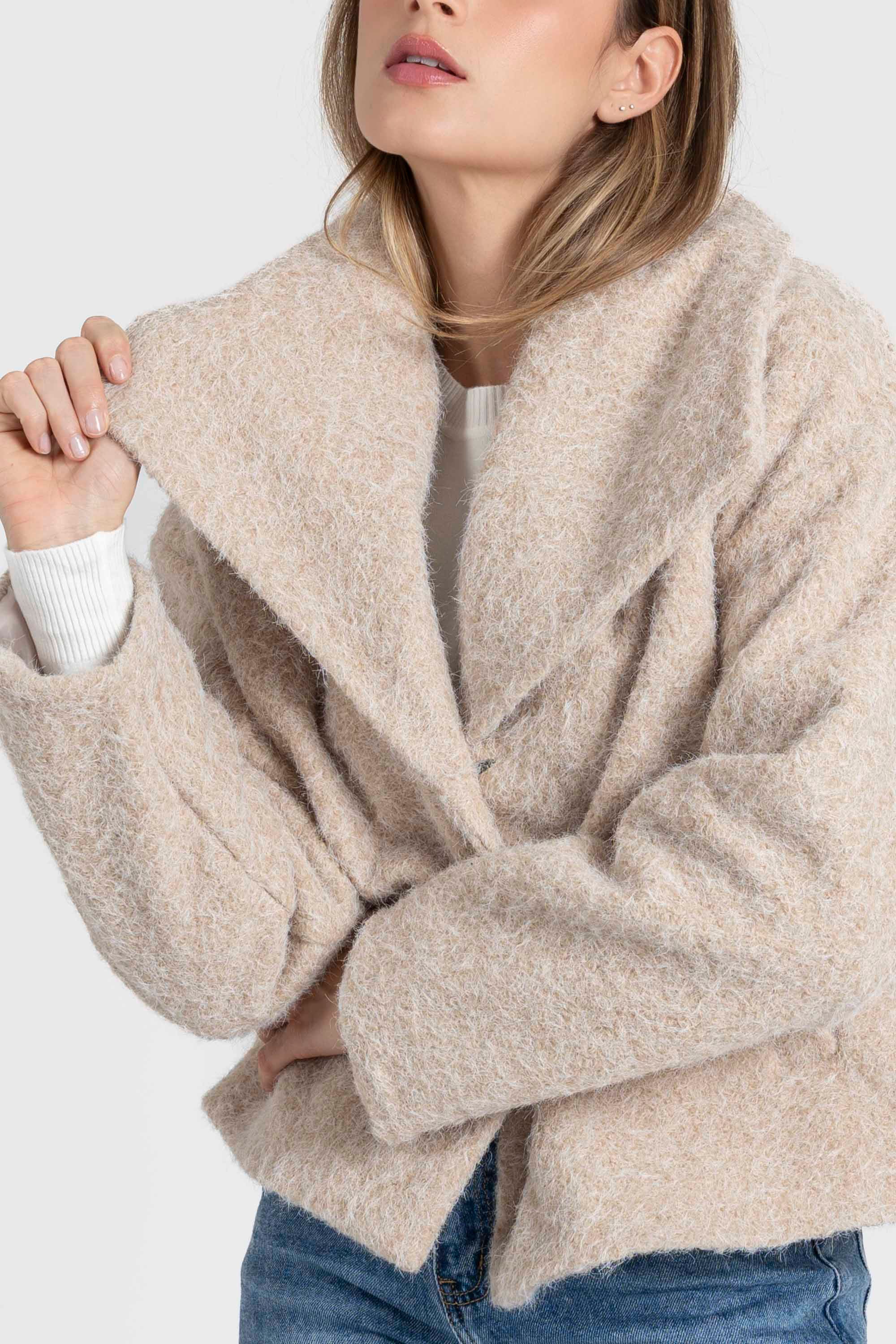 Détail d'une femme dans une veste courte effet poil doublée col à revers, soulignant le confort et le style. Veste courte femme.