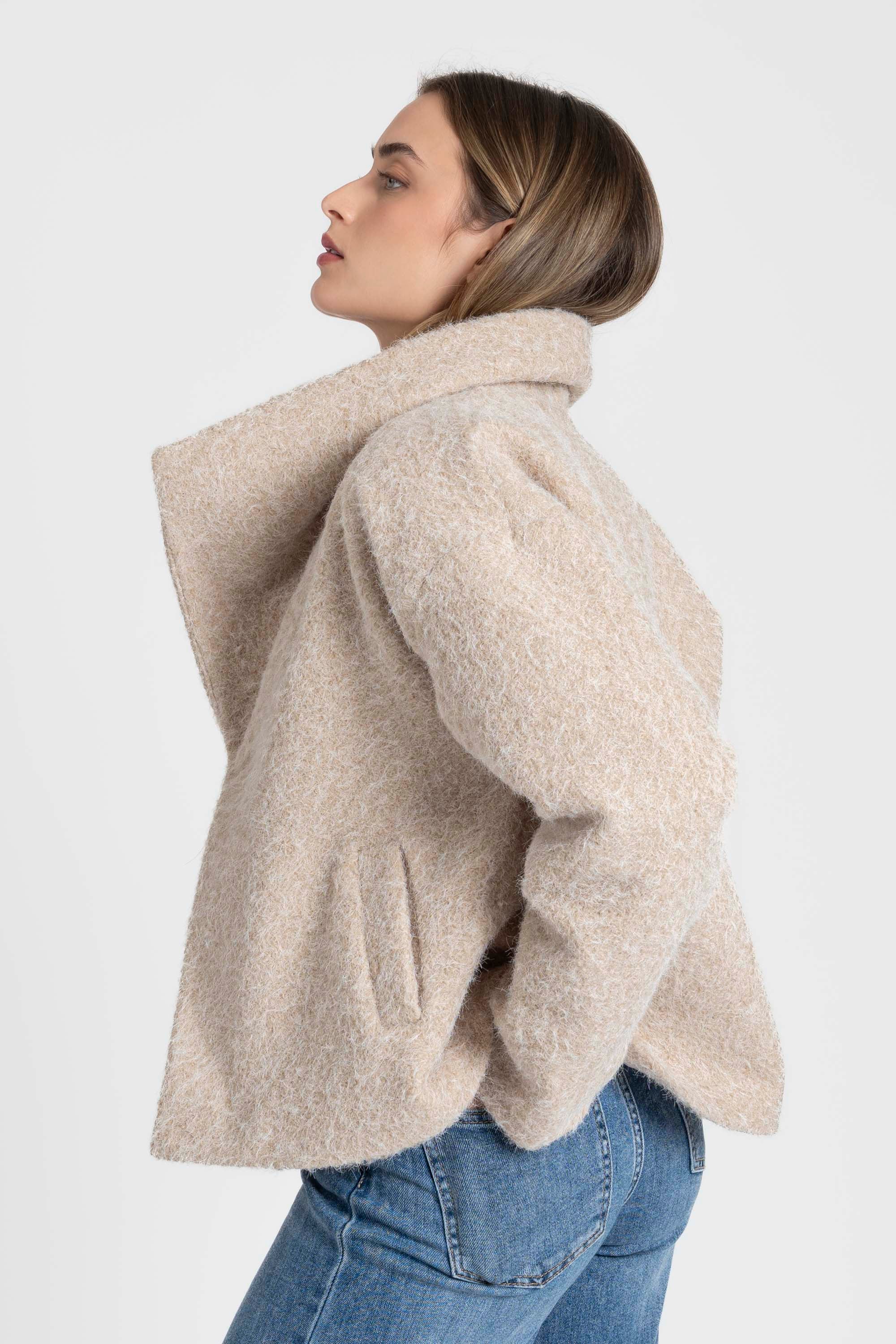 Profil d'une femme avec un look chic dans une veste courte effet poil doublée col à revers, parfait pour les saisons intermédiaires. Veste courte femme.