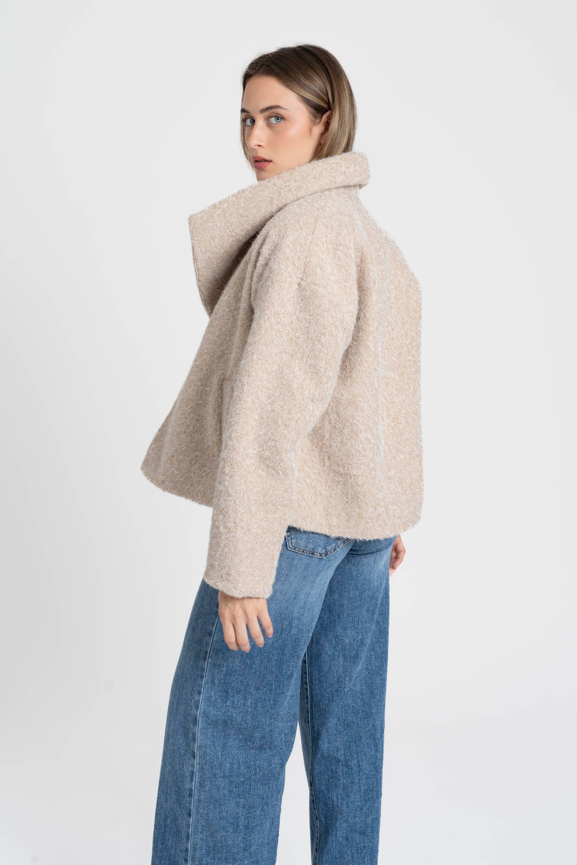 Vue arrière d'une femme avec une veste courte effet poil doublée col à revers beige, idéale pour compléter une tenue décontractée. Veste courte femme.