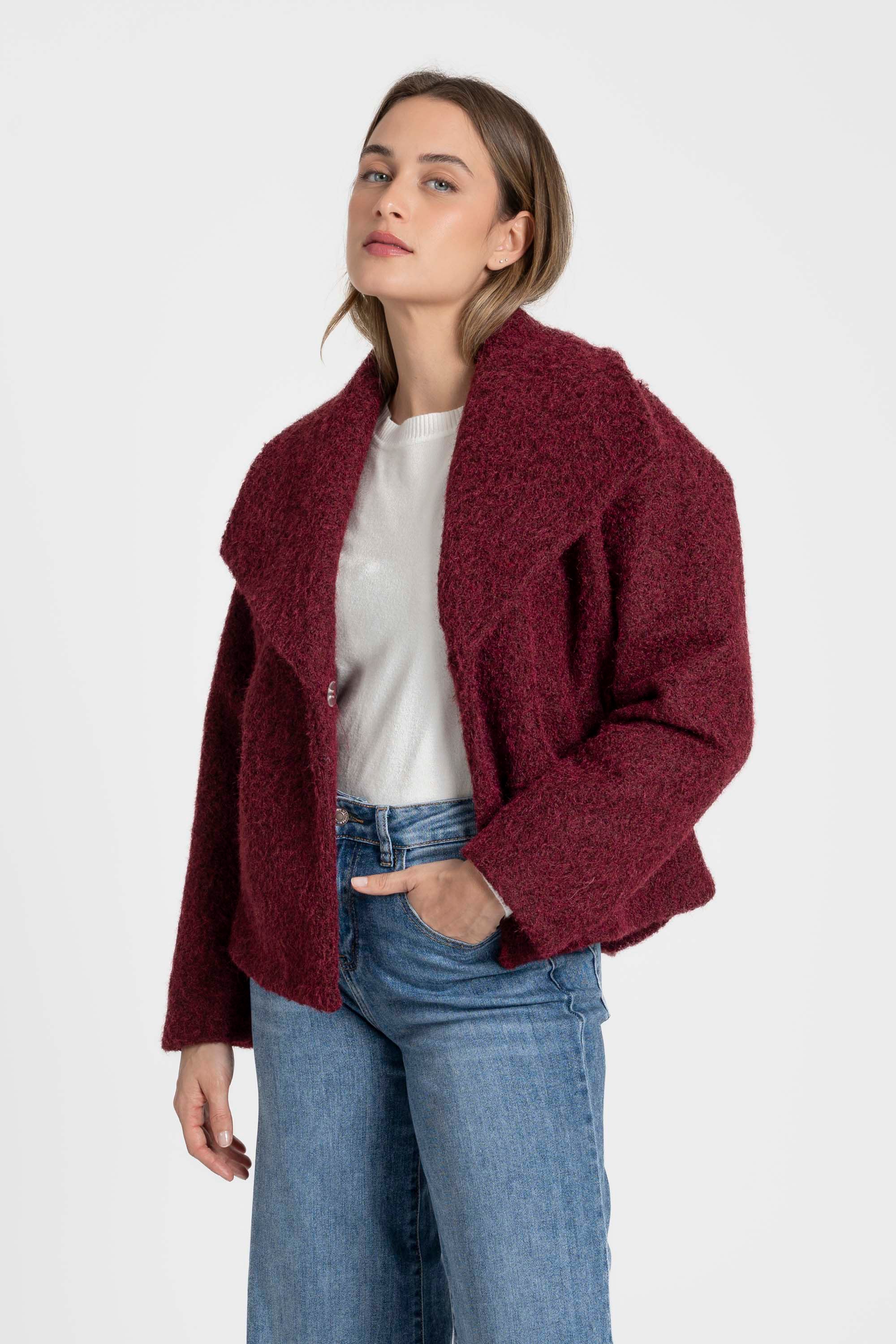 Femme avec une veste courte effet poil doublée col à revers en rouge, associée à un jean, parfaite pour un look d'automne. Veste courte femme.