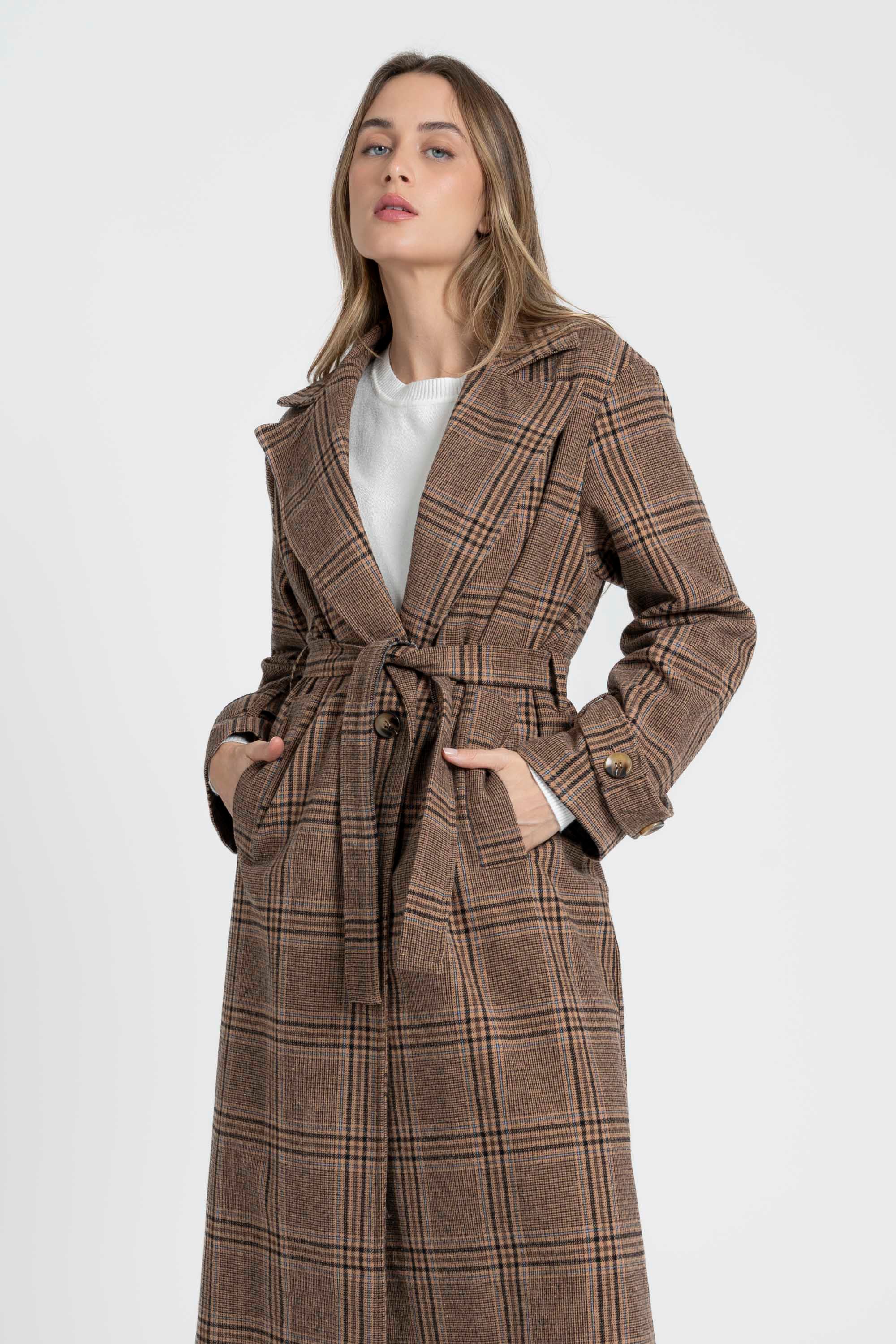 Manteau long femme en coton coupe ceinturée, vue rapprochée d'une femme le portant avec ceinture nouée, mettant en valeur la coupe et le motif de la vêtement.