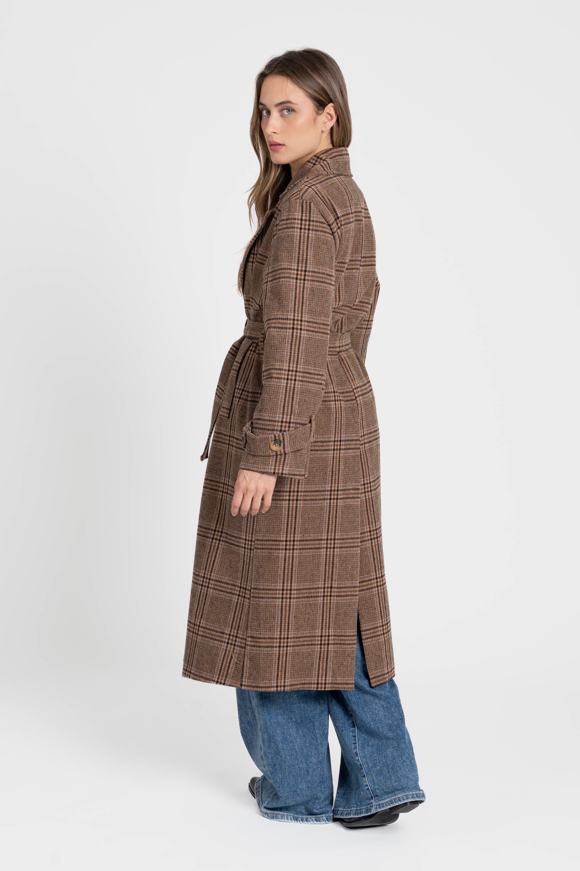 Manteau long femme en coton coupe ceinturée, vue arrière d'une femme le portant, révélant le drapé et la ceinture dans le dos.