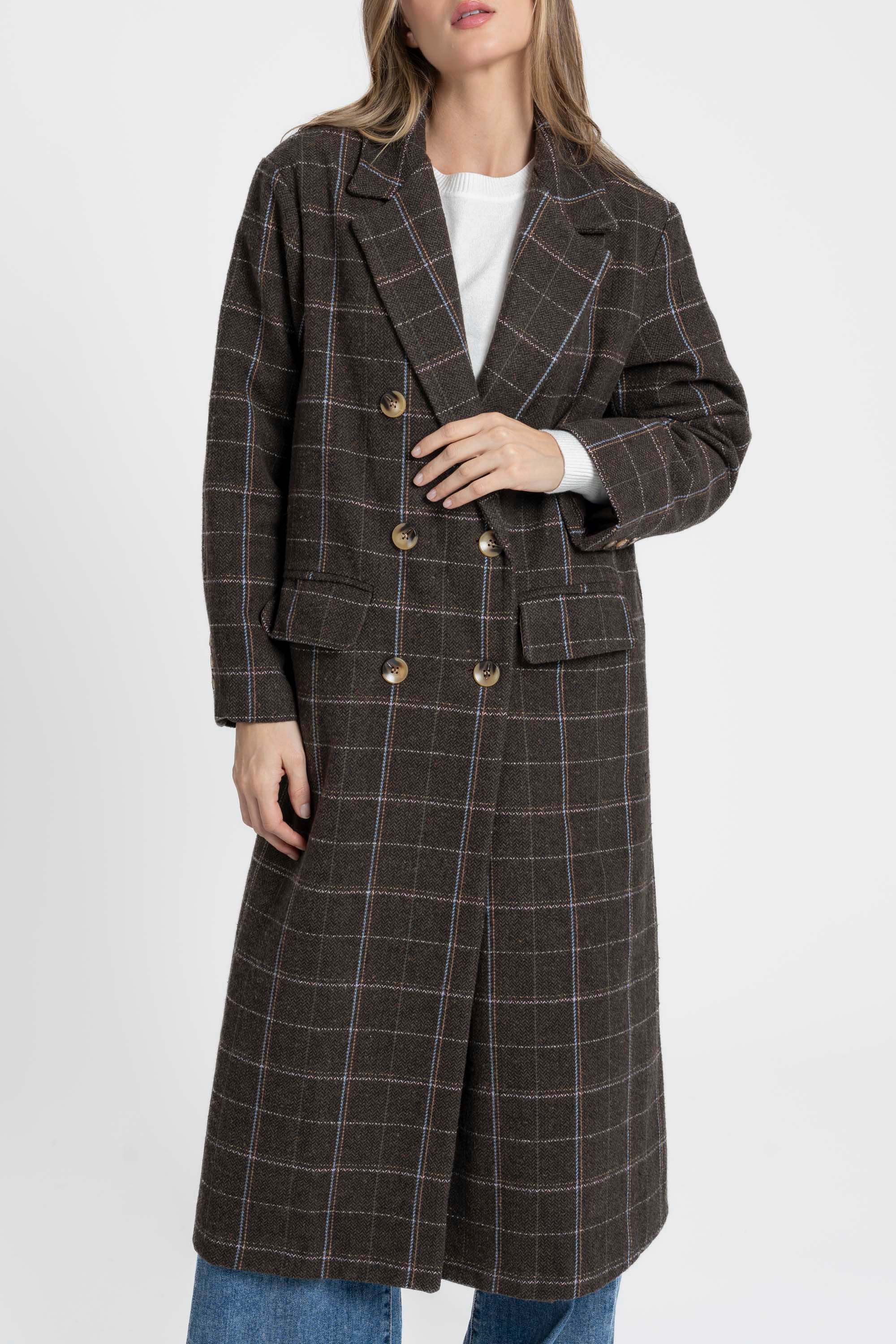 Gros plan sur une femme tenant un manteau long croisé marron en coton mélangé, mettant en avant les détails des boutons et la texture du tissu. Manteau long croisé femme en coton mélangé marron.