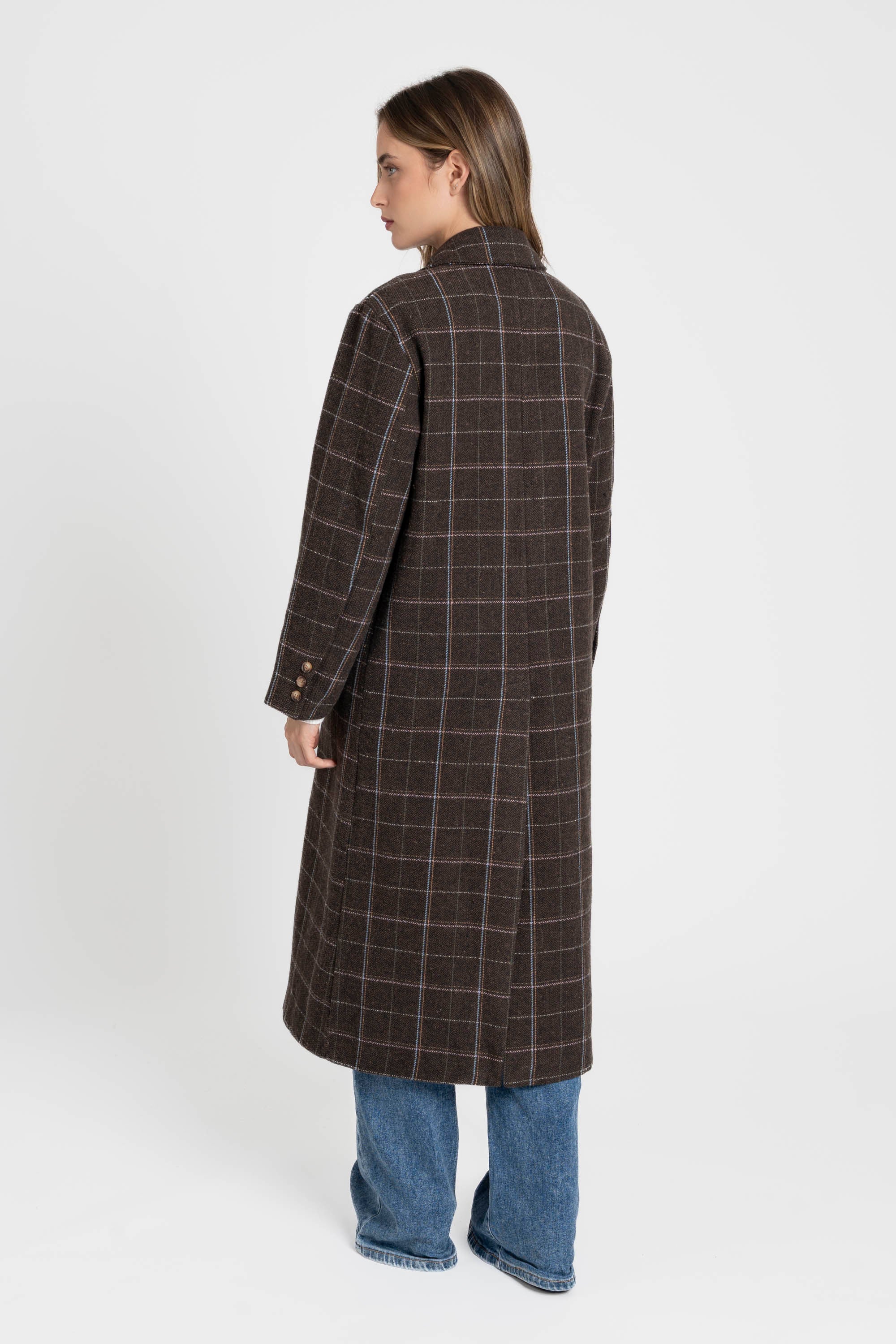 Vue arrière d'une femme habillée d'un manteau long croisé marron en coton mélangé, mettant en avant la coupe élégante et structurée. Manteau long croisé femme en coton mélangé marron.