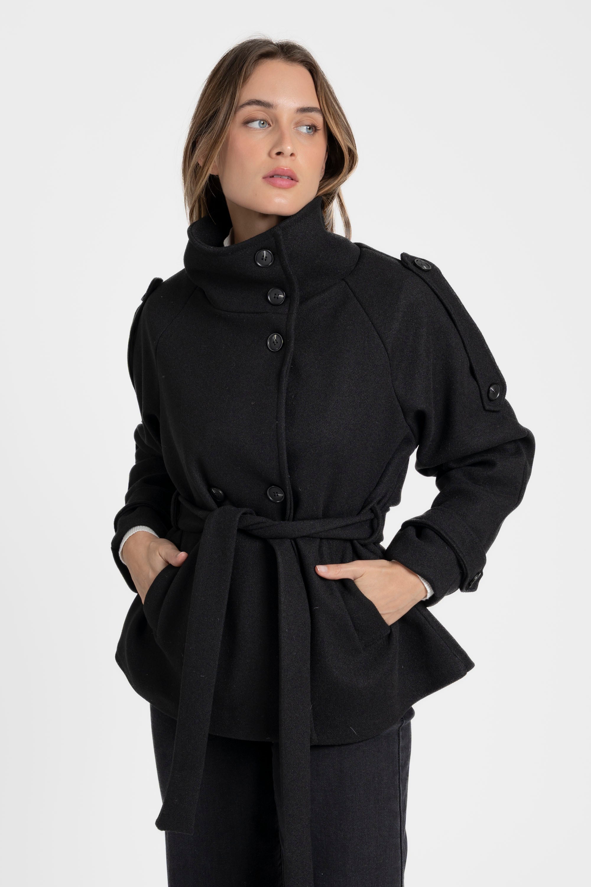 Femme souriant dans une veste femme col montant coupe droite noire, avec un col relevé et boutons, idéale pour une allure élégante.