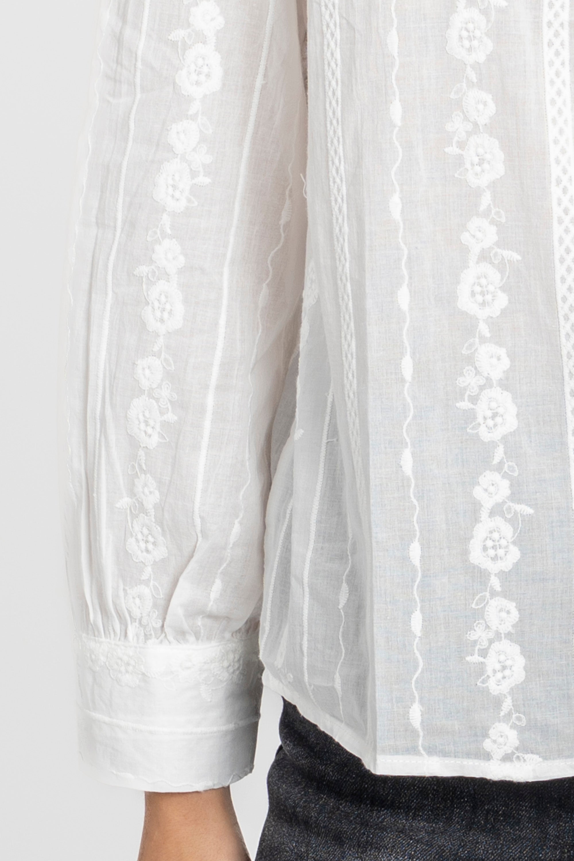 Chemise blanche brodée portée par un mannequin, idéale pour le quotidien avec une touche élégante.