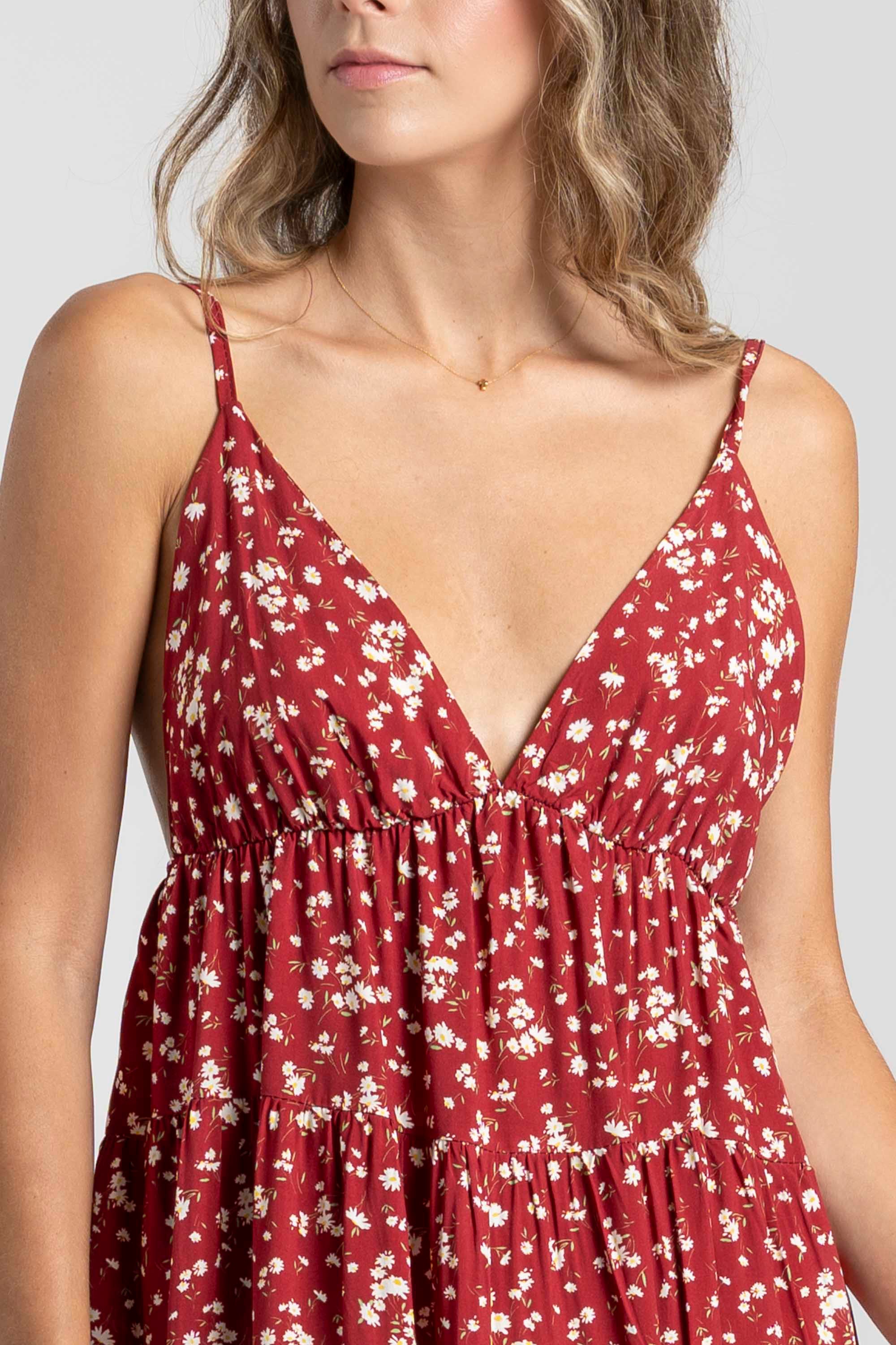 Détail de la poitrine d'une robe fluide en viscose à bretelles fines, couleur bordeaux, avec motif floral discret.