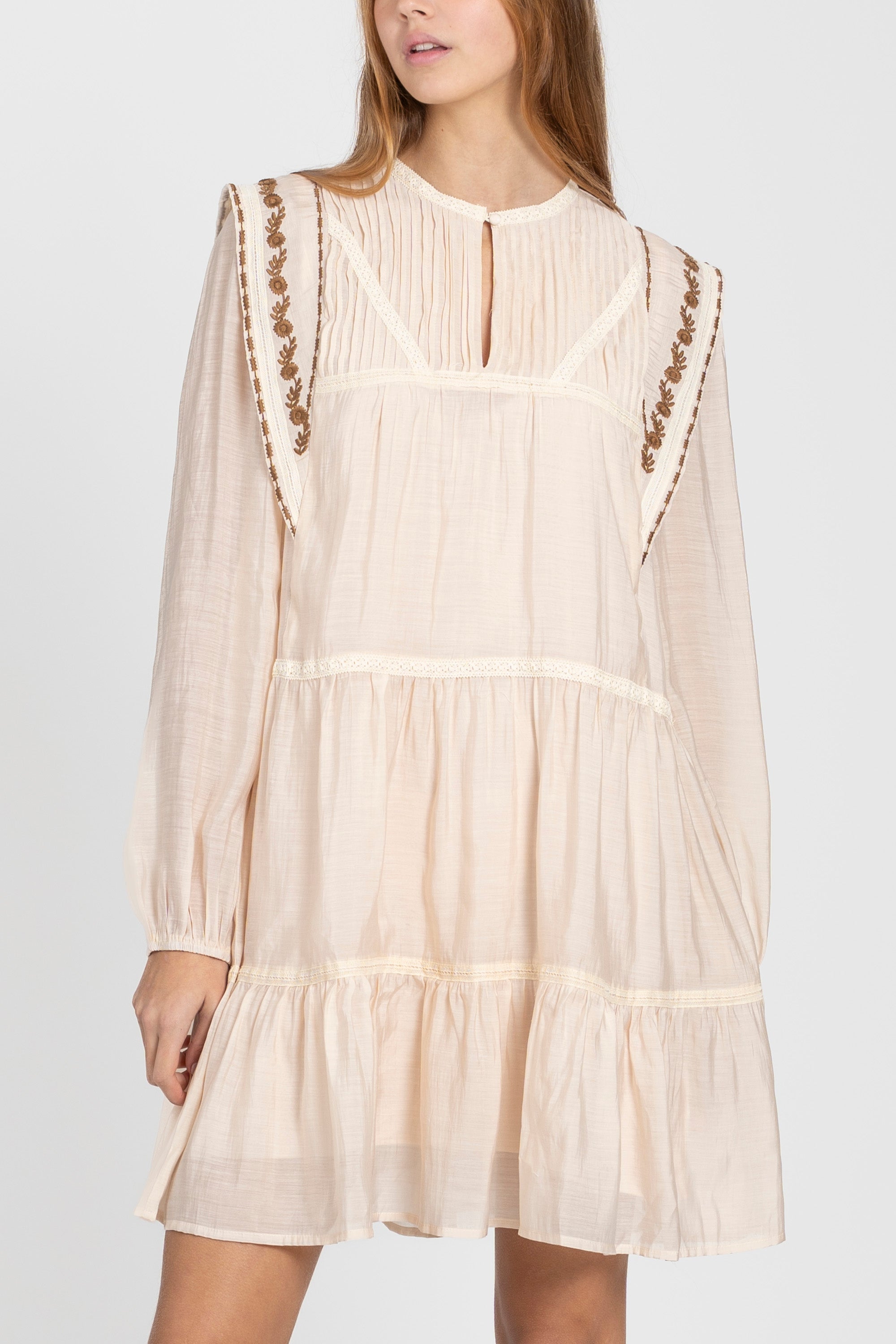 Vue rapprochée de la robe fluide brodée élégante, mettant en valeur les détails de broderie et la coupe aérienne.