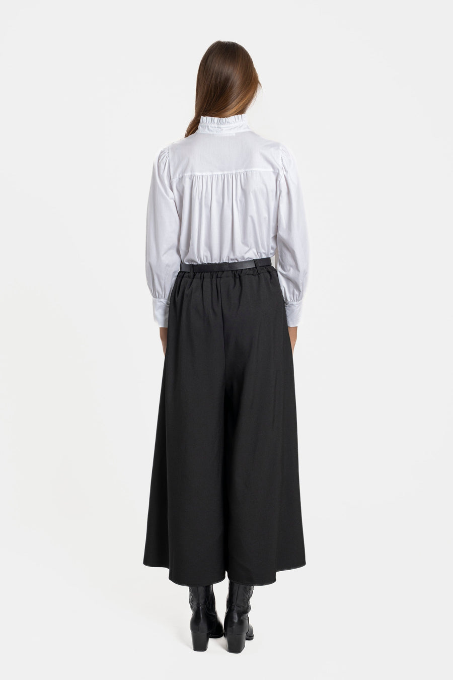 Vue arrière d'une femme en pantalon fluide taille haute femme noir, soulignant le style et la coupe moderne.