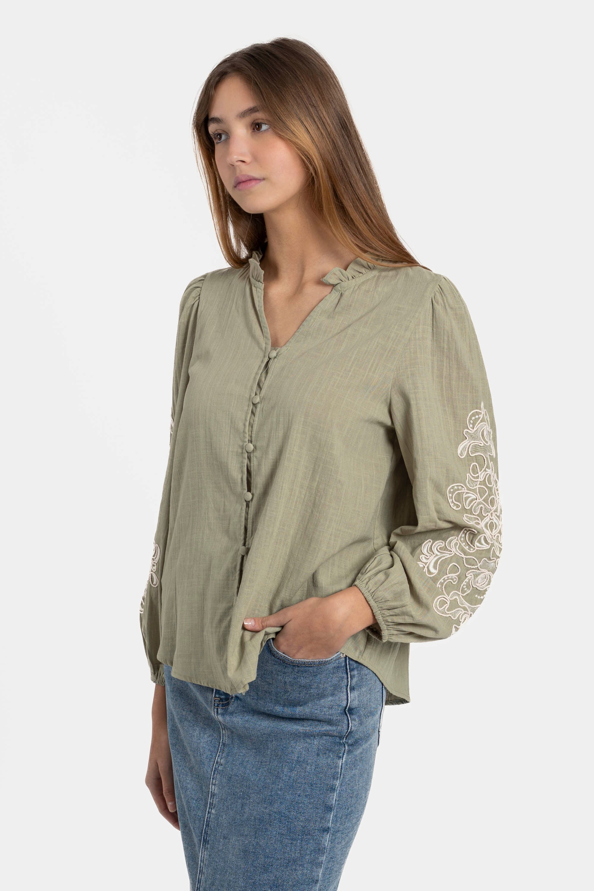 Femme portant une chemise brodée en coton avec manches longues élégantes, affichant un style casual chic. Chemise brodée femme idéale pour toutes les occasions.
