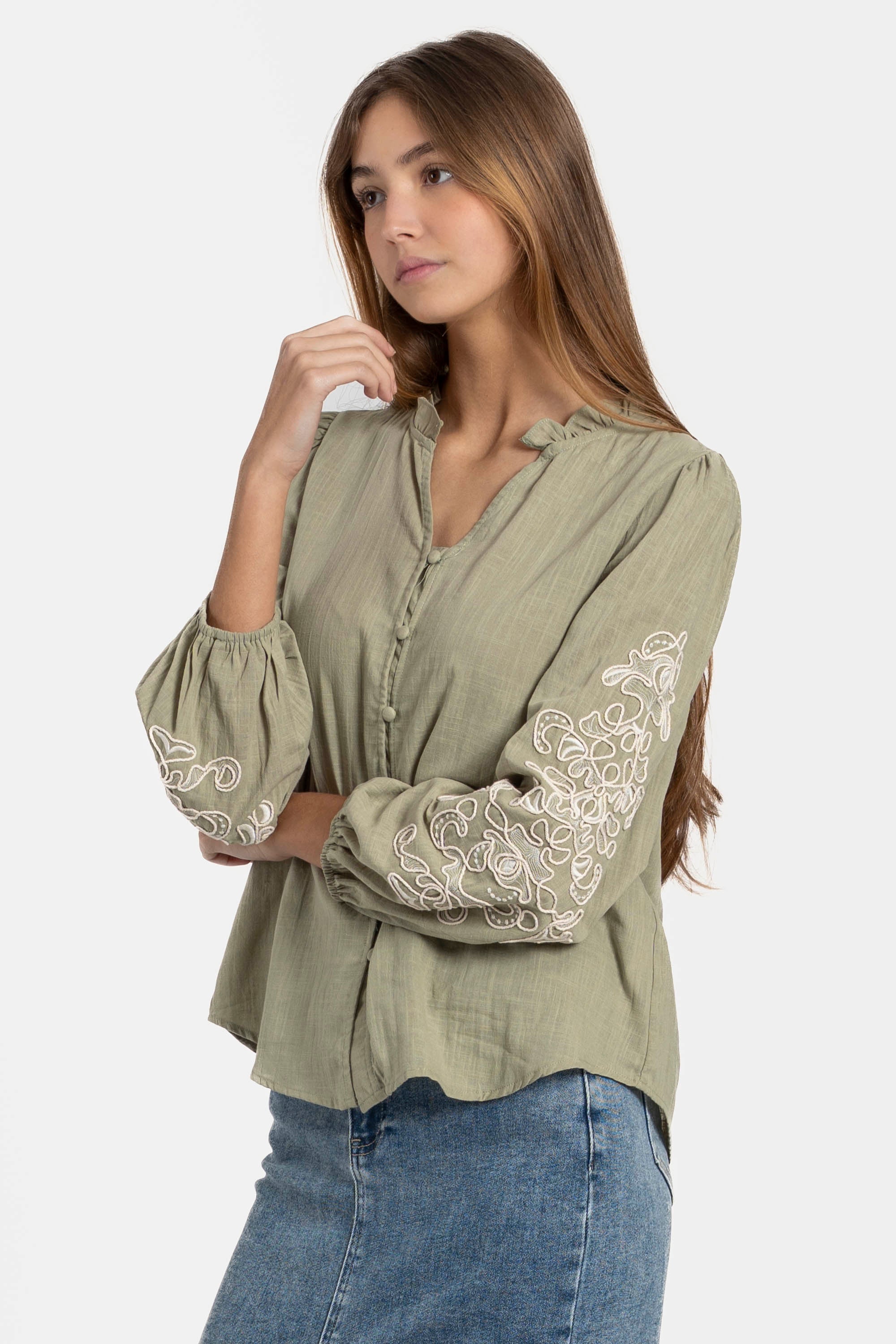 Femme posant avec une chemise brodée en coton, manches longues élégantes, parfaite pour un style casual chic. Chemise brodée femme à la mode.