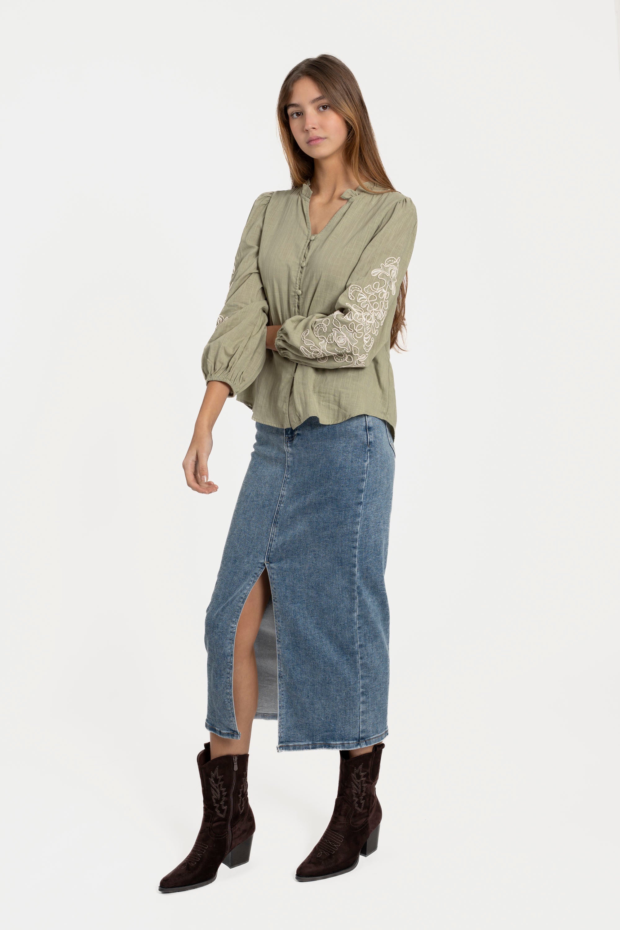 Femme en chemise brodée en coton avec manches longues, associée à une jupe, pour un look élégant et décontracté. Chemise brodée femme polyvalente.