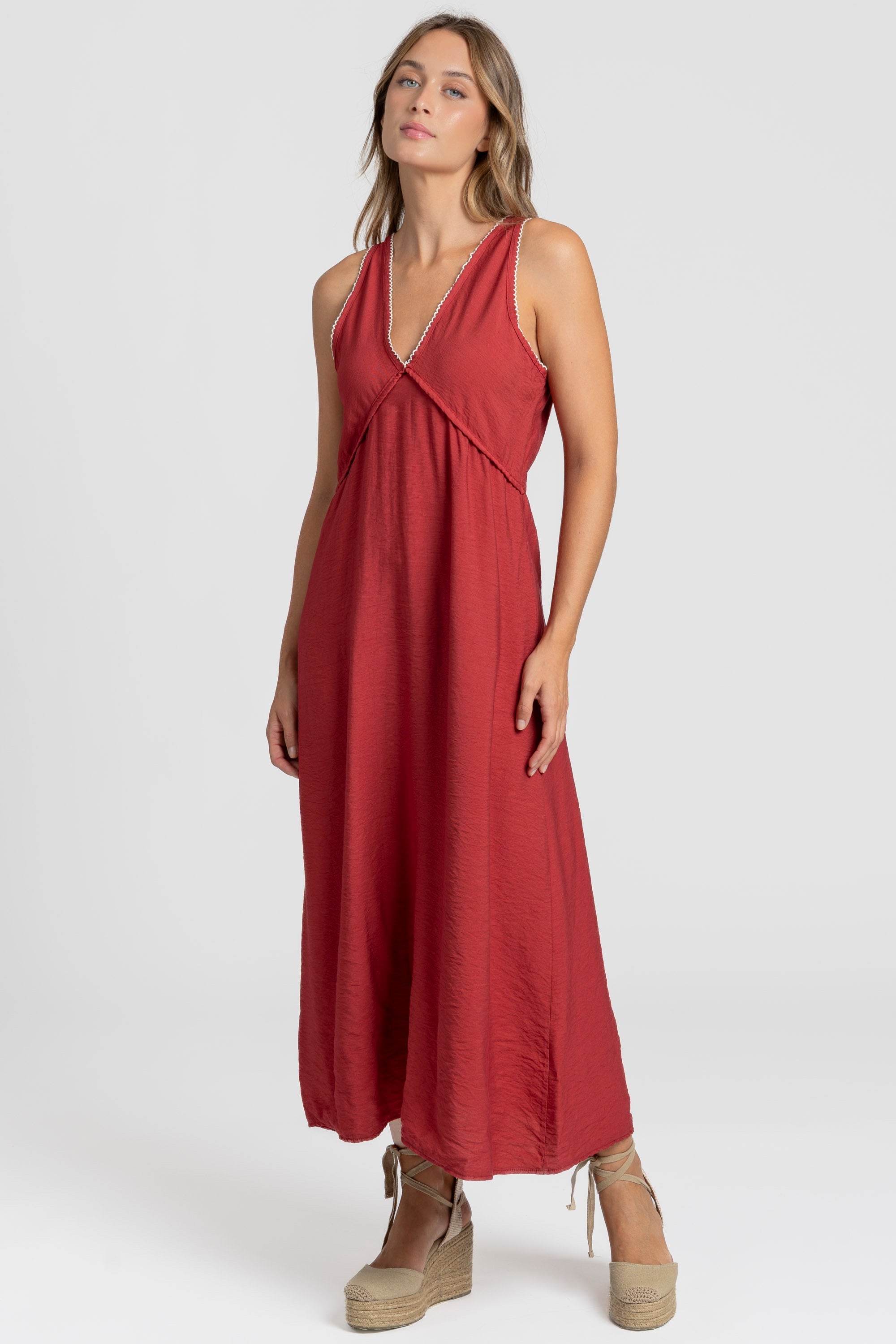 Robe midi fluide brodée en viscose confortable, portée par une femme, couleur rouge, décolleté en V et broderies raffinées.