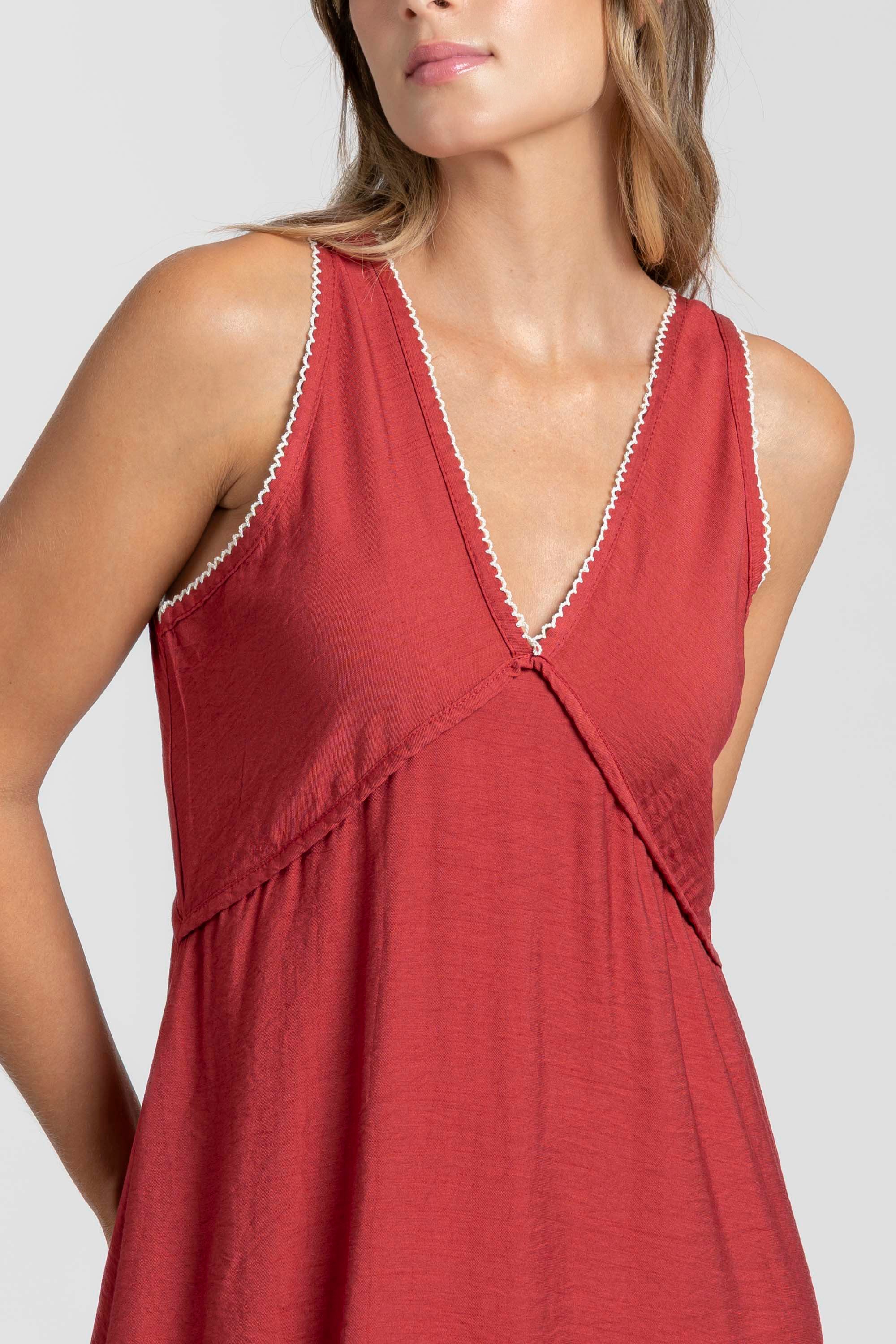 Détail de la robe midi fluide brodée en viscose confortable, couleur rouge, mettant en avant le décolleté en V.