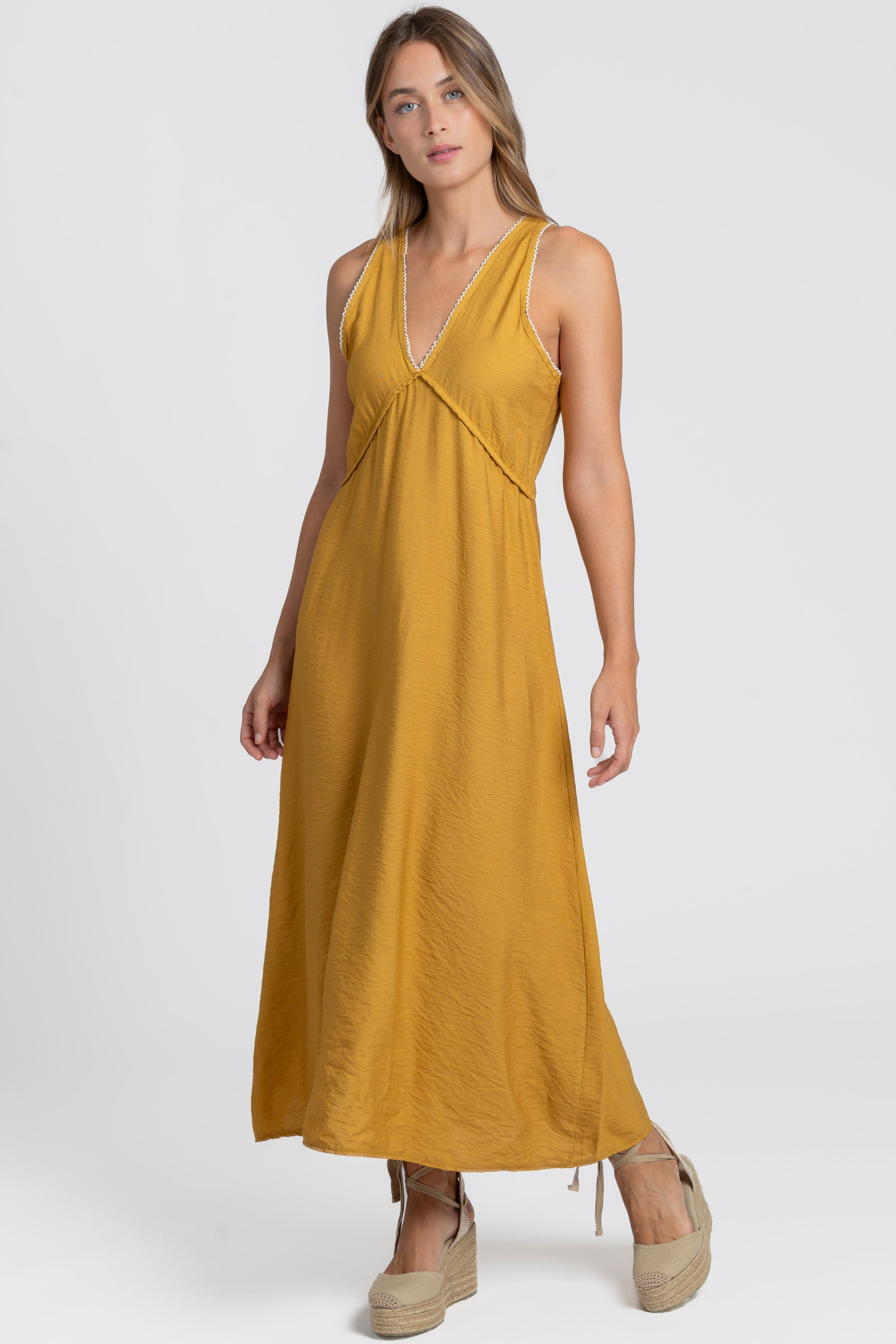 Robe midi fluide brodée en viscose confortable, portée par une femme, couleur jaune, décolleté en V, style détendu.