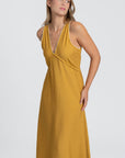 Détail de la robe midi fluide brodée en viscose confortable, couleur jaune, soulignant le décolleté et le tissu.