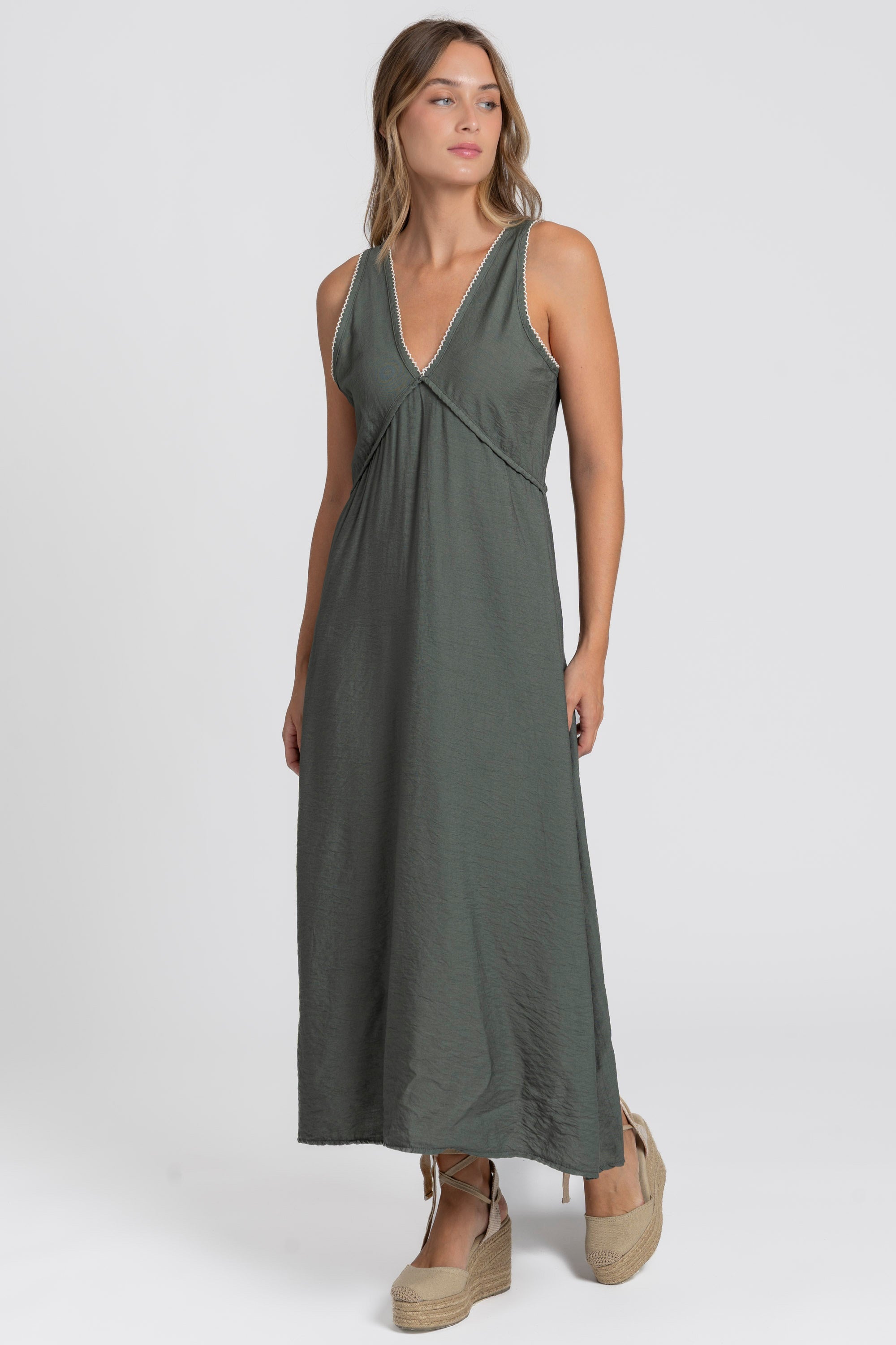 Robe midi fluide brodée en viscose confortable, portée par une femme, couleur verte, décolleté en V et look élégant.