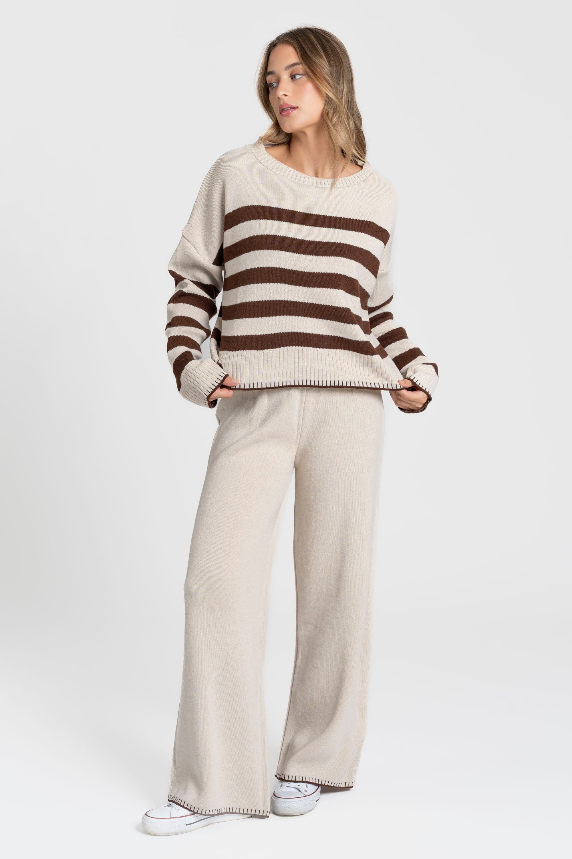Ensemble maille rayée femme : pull à rayures marron et beige accompagné d'un pantalon large.
