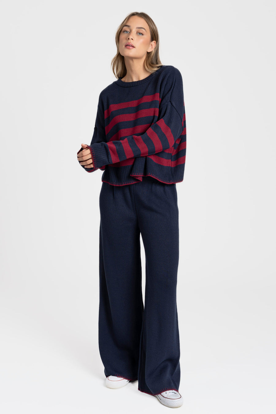 Ensemble maille rayée femme : gros plan sur un pull bleu à rayures rouges, look tendance.