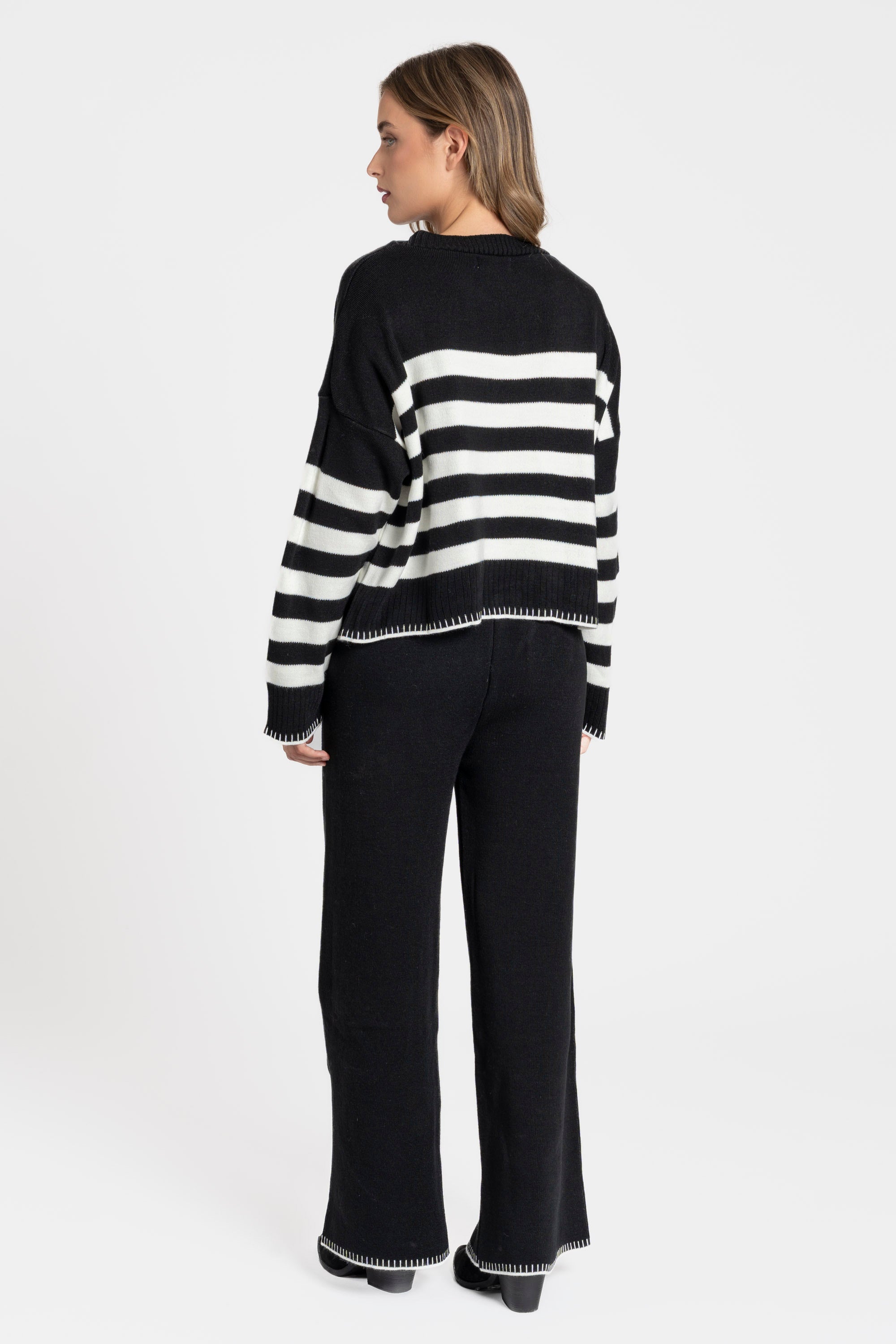 Ensemble maille rayée femme : modèle noir à rayures blanches avec un look décontracté.