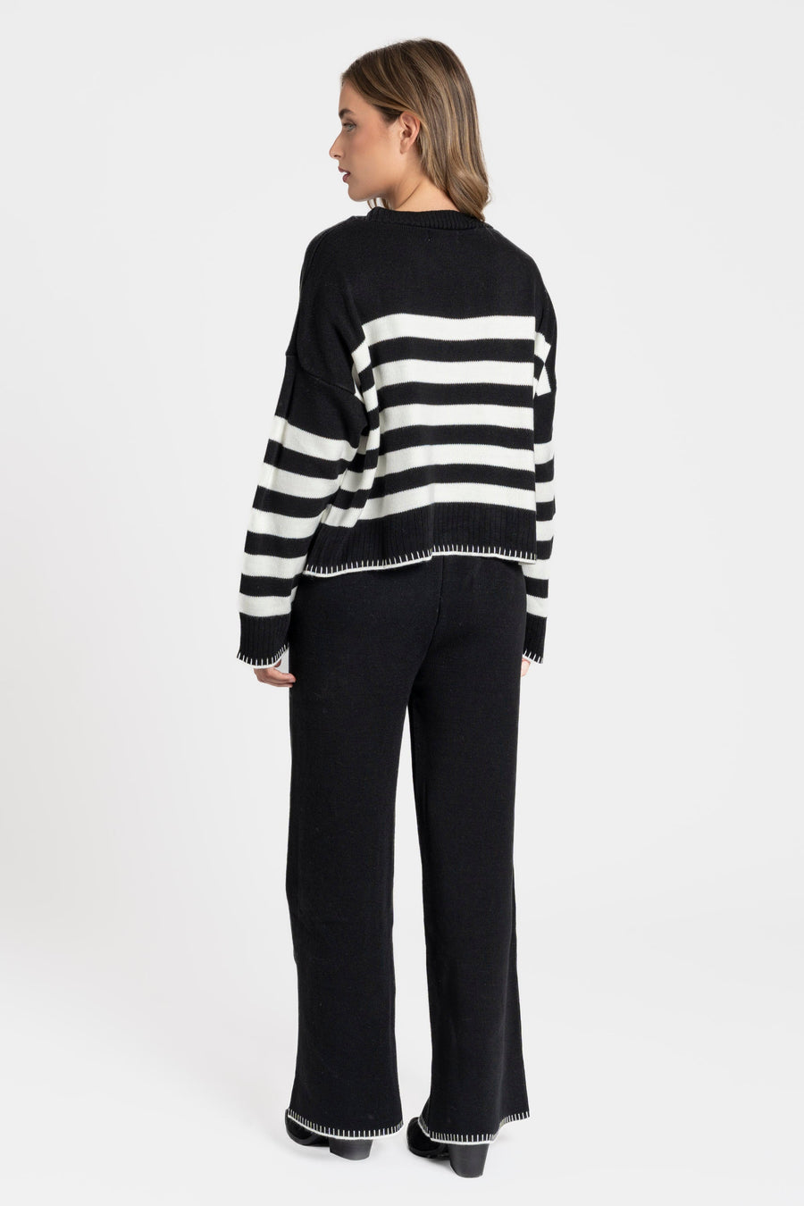 Ensemble maille rayée femme : modèle noir à rayures blanches avec un look décontracté.