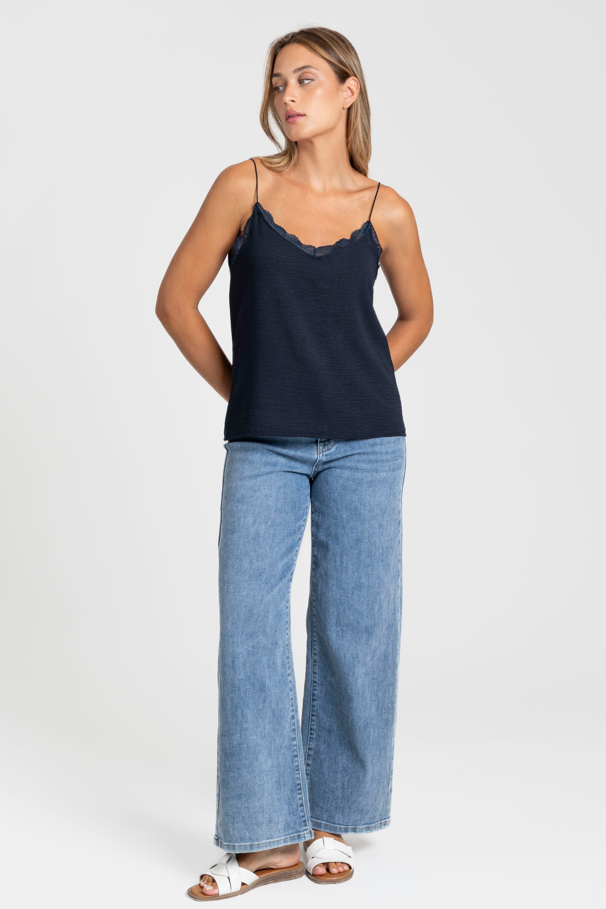 Top en mousseline femme fluide à bretelles avec dentelle bleu foncé, en vue suspendue, élégant et versatile.