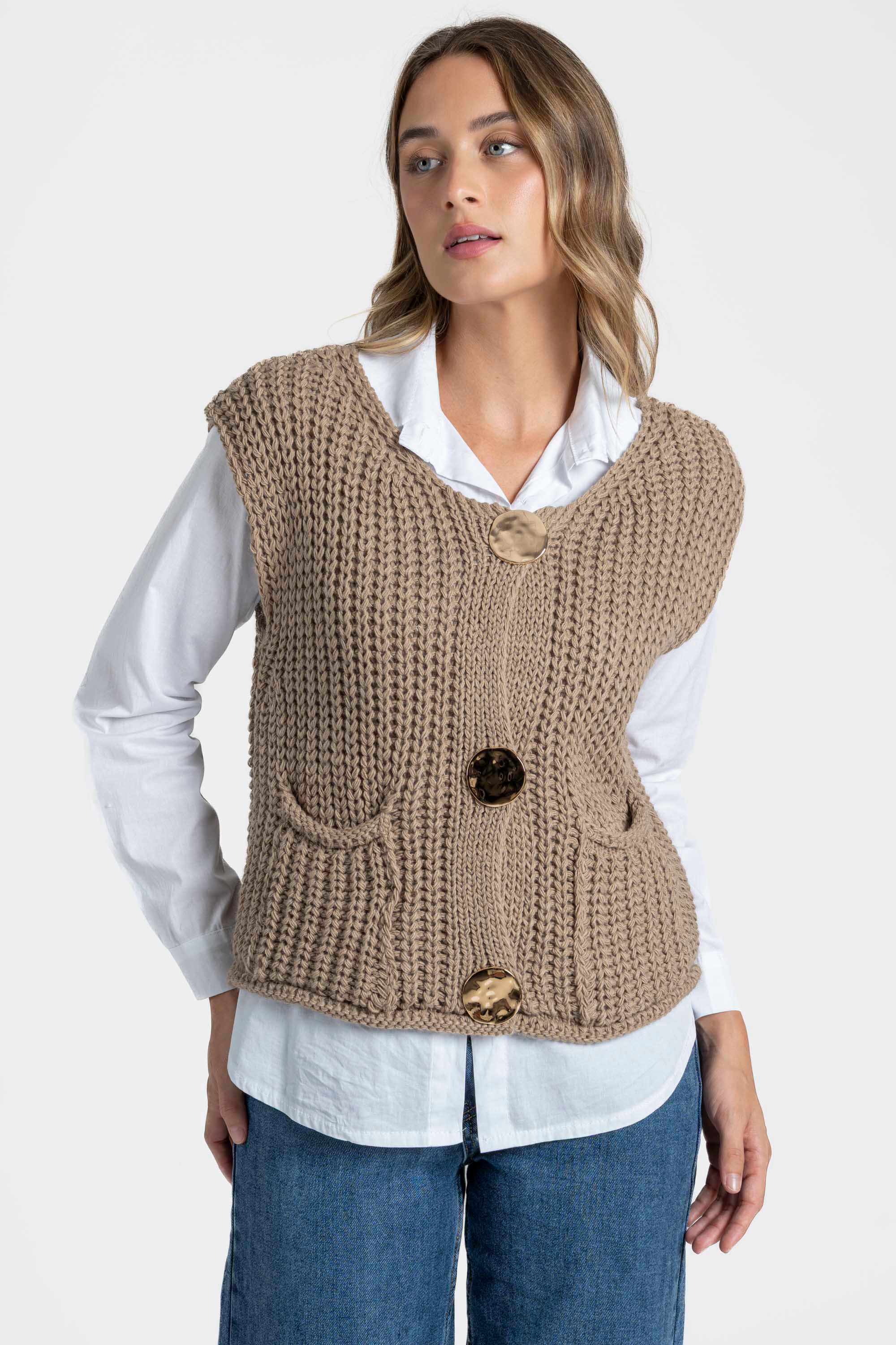 Modèle féminin avec gilet sans manches en maille femme beige, photographié de côté pour mettre en avant la coupe. Gilet maille femme.