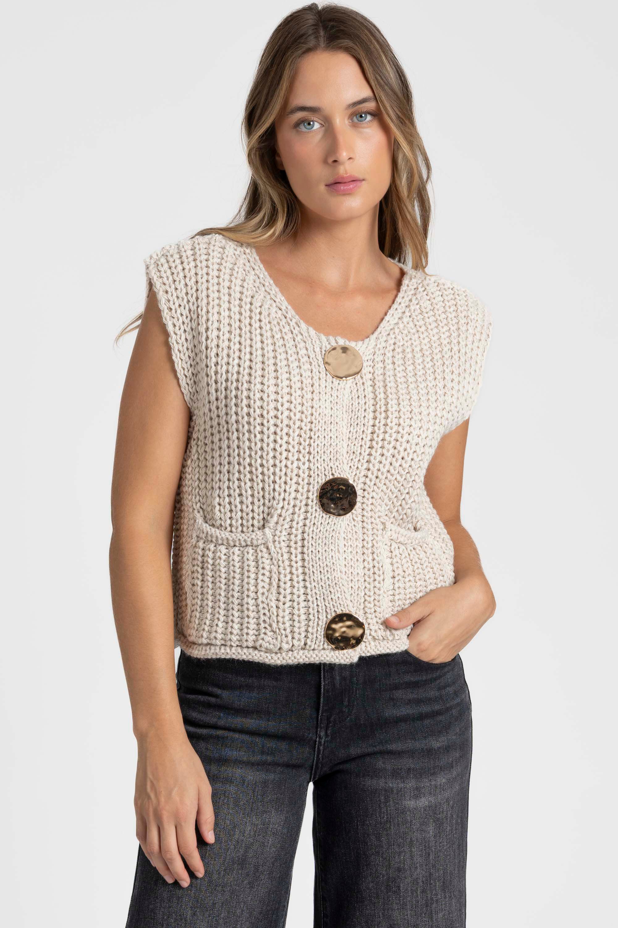 Gilet sans manches en maille femme crème, affiché de face, mettant en avant les boutons métalliques, associé à un look casual. Gilet maille femme.