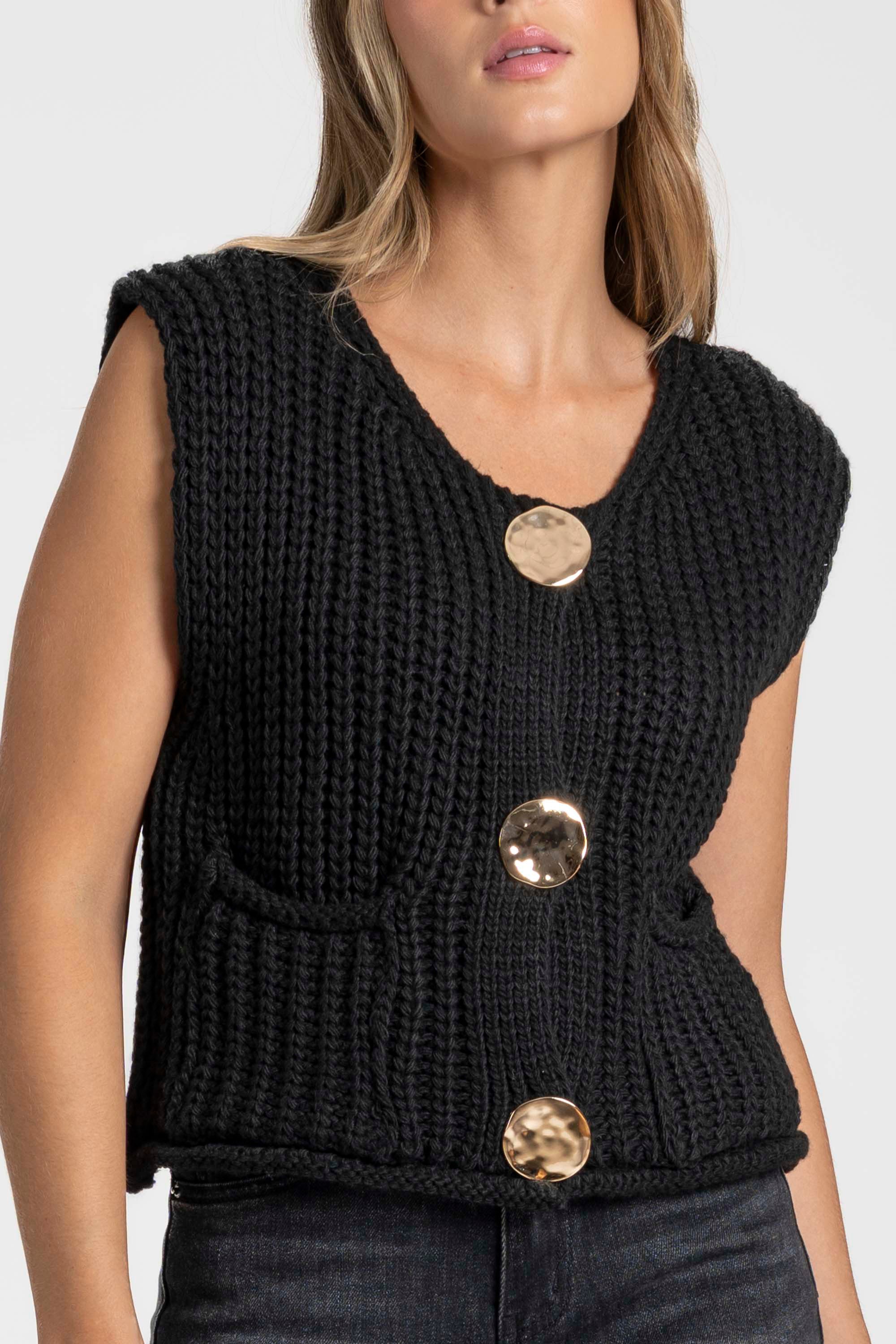 Gilet sans manches en maille femme noir, montré de face, mettant en valeur ses boutons métalliques et sa coupe moderne. Gilet maille femme.