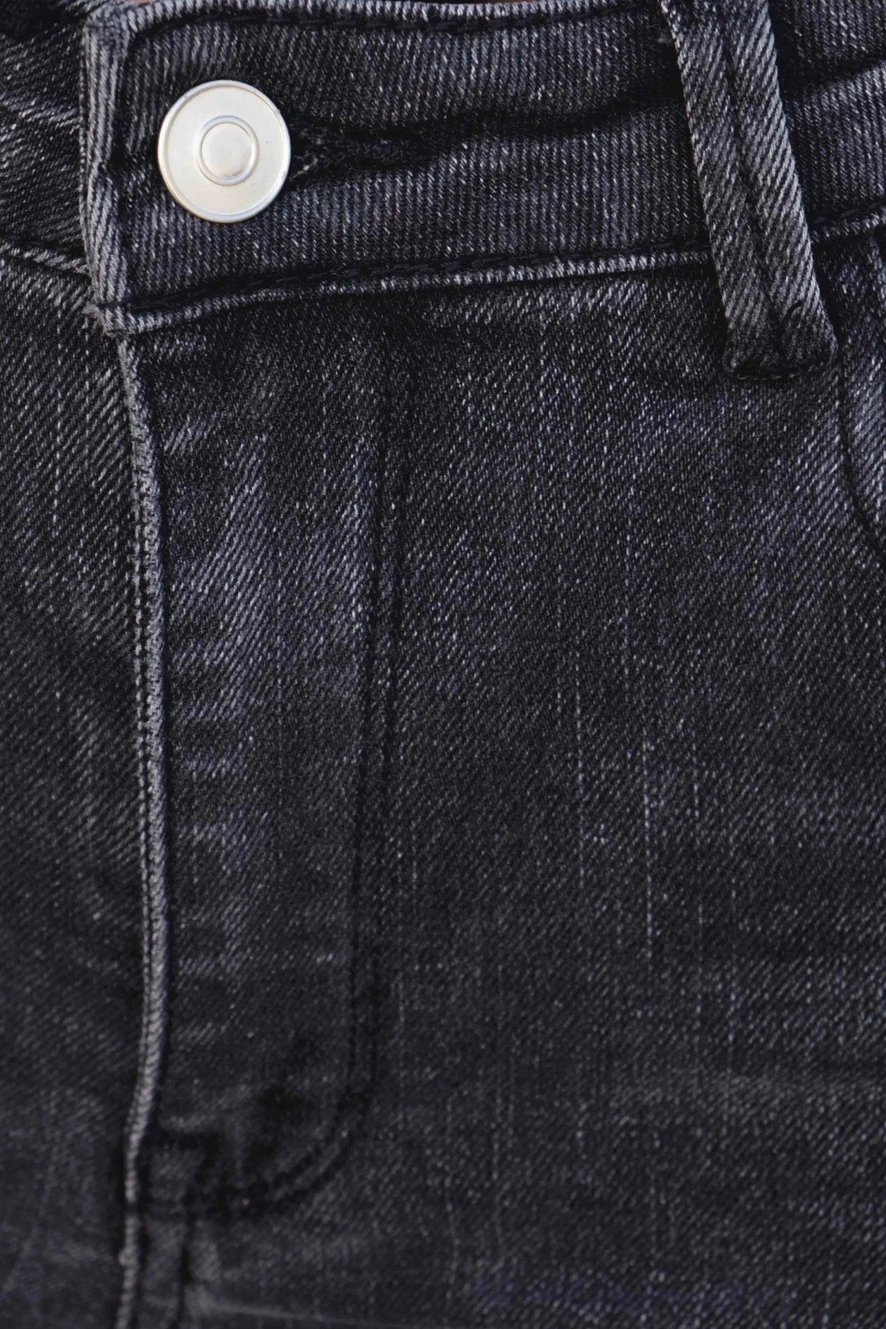 Détail zoom sur la texture du jean femme gris évasé, soulignant la qualité du tissu pour un look à la fois chic et confortable.