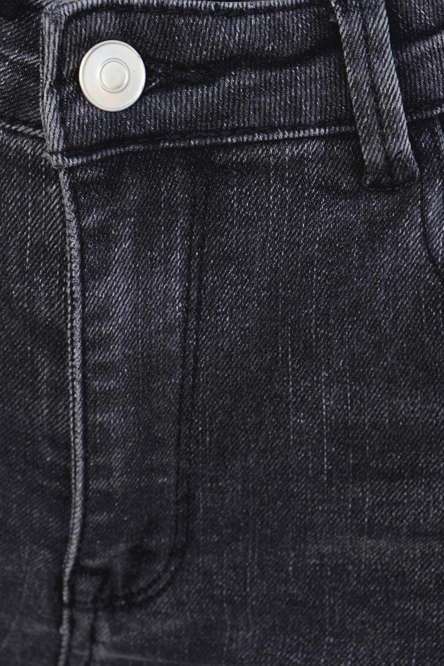 Détail zoom sur la texture du jean femme gris évasé, soulignant la qualité du tissu pour un look à la fois chic et confortable.