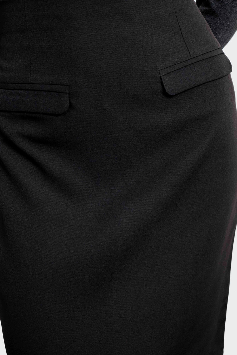 Zoom sur une jupe midi noire avec détails de poches, conçue pour un style chic et moderne.