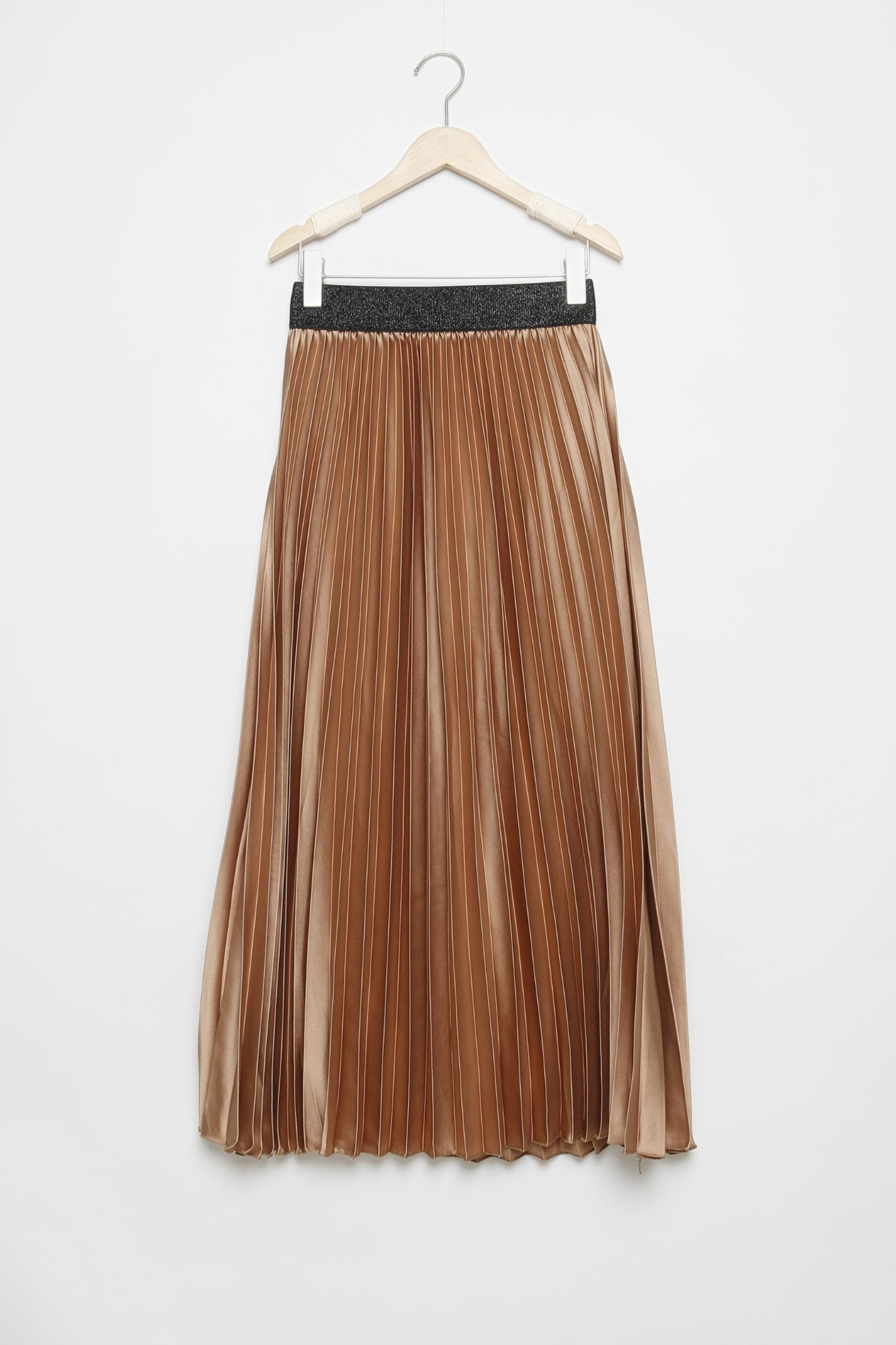 Jupe midi plissée brillante taille haute de couleur camel suspendue sur un cintre.