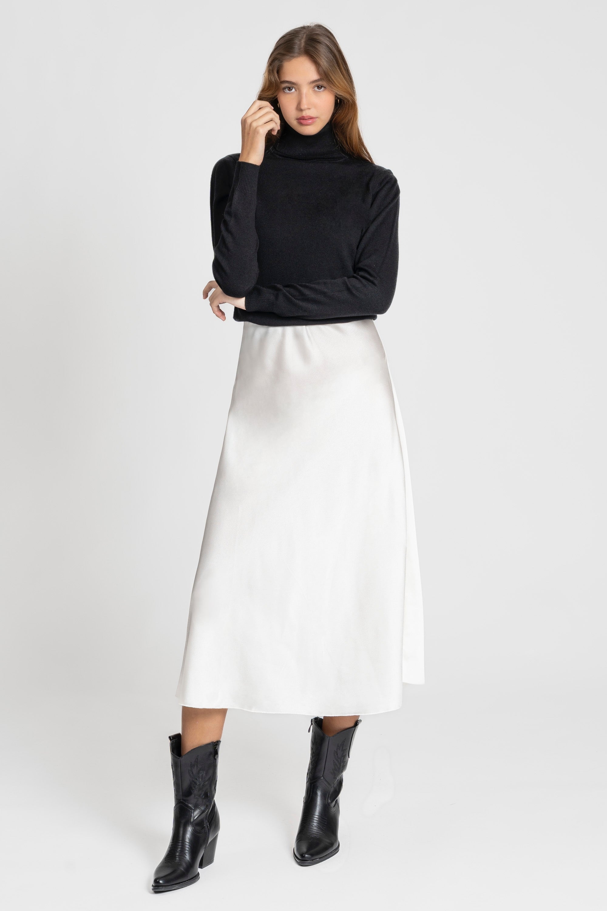 Modèle portant une jupe midi droite satinée taille élastique en tissu 100% polyester, idéale pour un look élégant au quotidien.