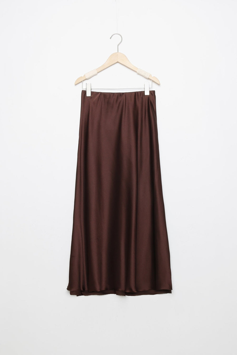 Jupe midi droite satinée en brun foncé, suspendue pour afficher la texture du tissu et la taille élastique.