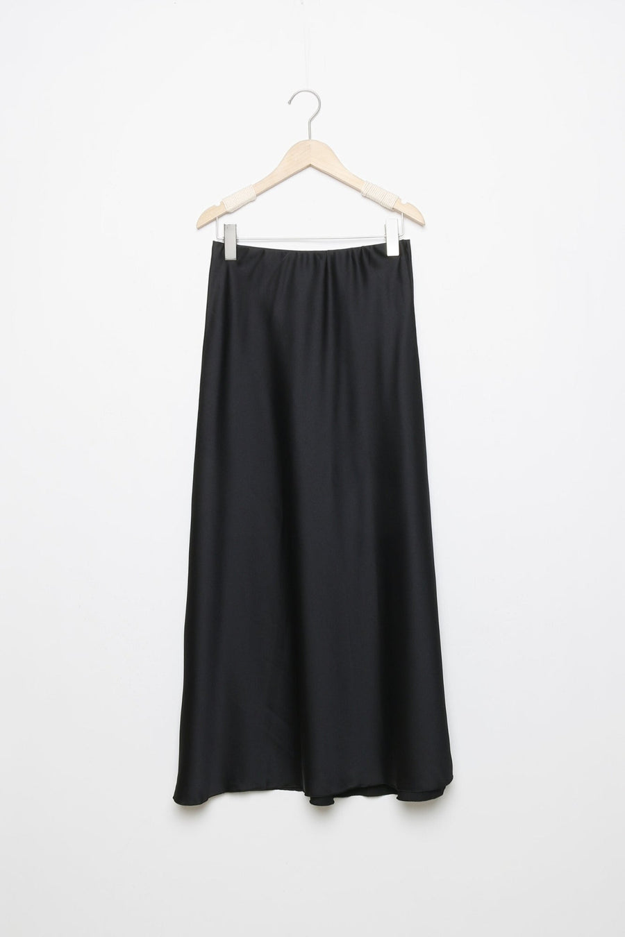 Jupe midi droite satinée noire sur un cintre, montrant la finition soignée en 100% polyester.