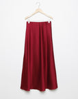 Jupe midi droite satinée en rouge, suspendue, mettant en avant sa coupe élégante et son tissu brillant.