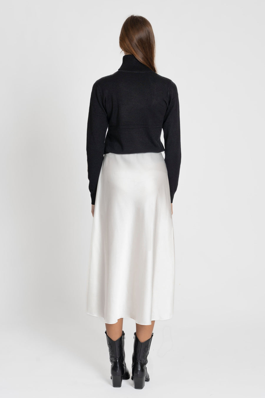 Vue arrière d'un modèle en jupe midi droite satinée, mettant en avant la taille élastique confortable en 100% polyester.