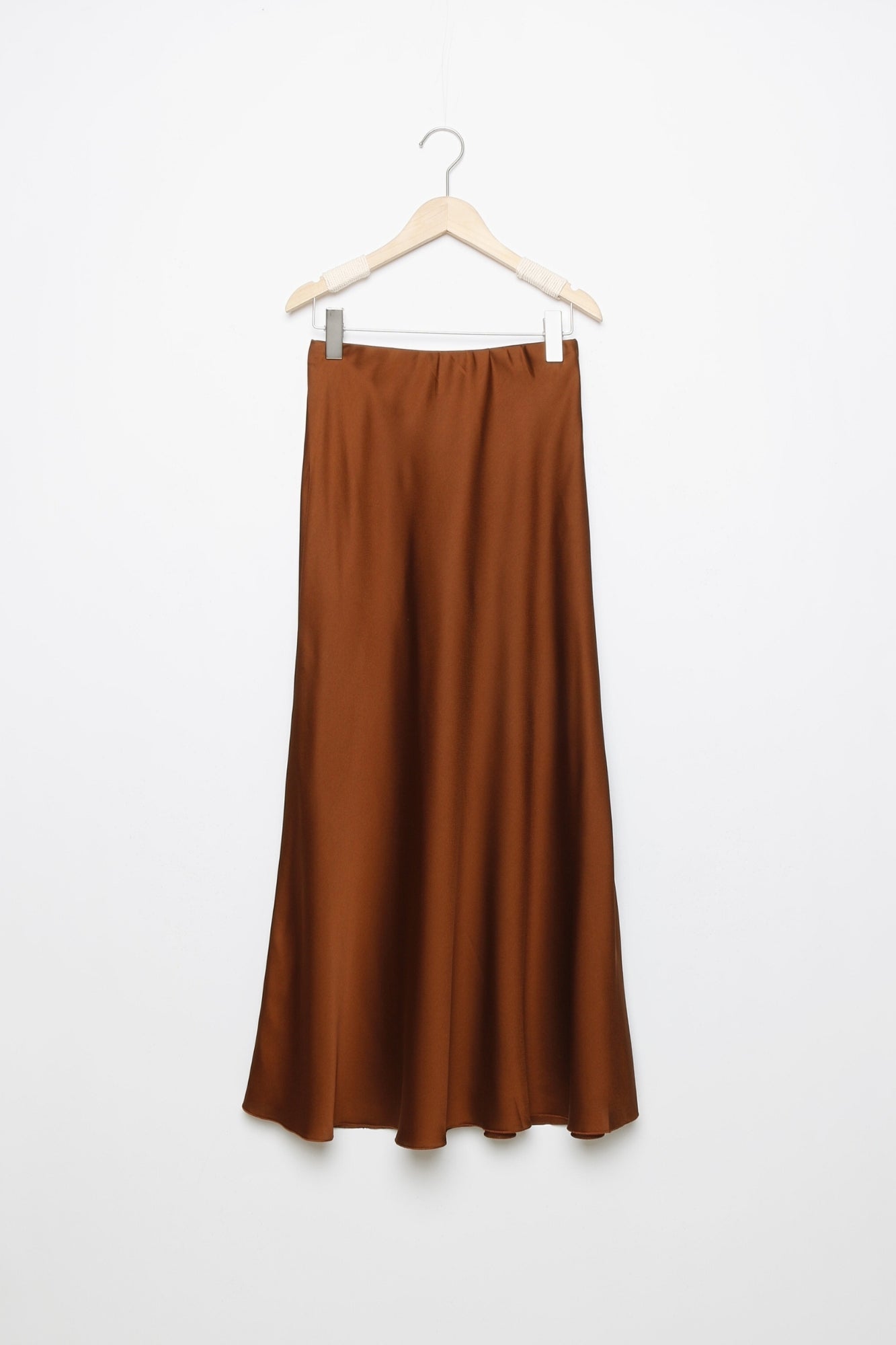 Jupe midi droite satinée en couleur marron sur un cintre, idéale pour des occasions variées.