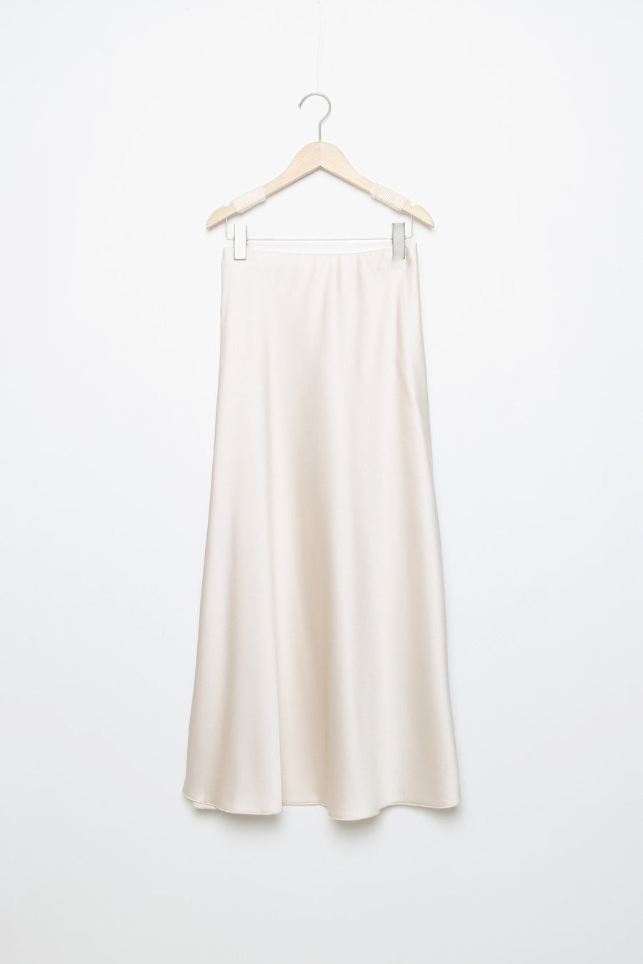 Jupe midi droite satinée de couleur beige, suspendue, avec une taille élastique pour un ajustement facile.