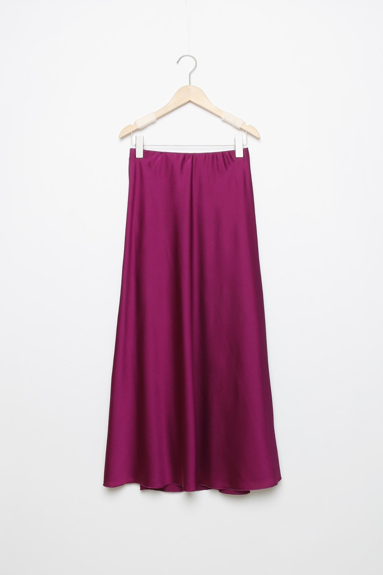 Jupe midi droite satinée en violet, affichée sur un cintre, pour des looks à la fois chic et décontractés.