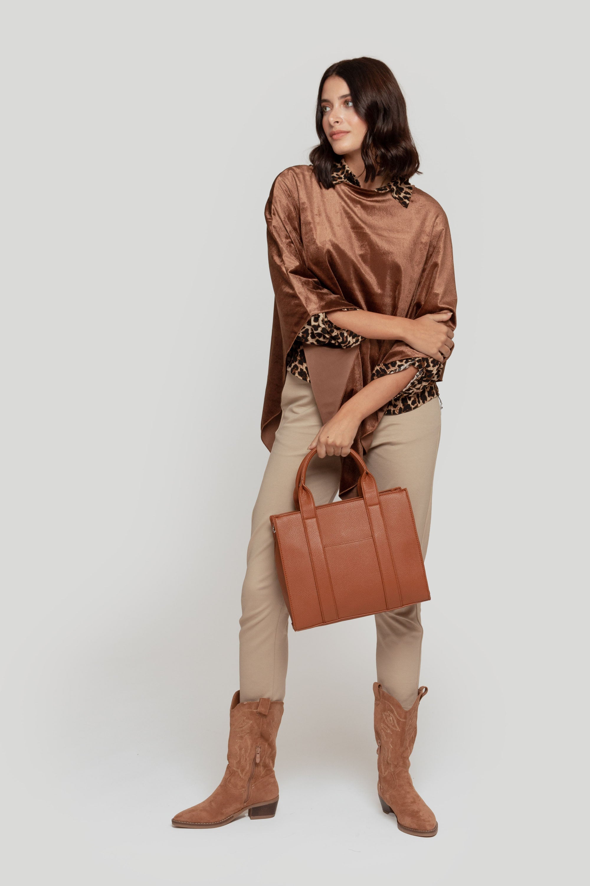 Femme portant un pantalon fluide taille haute en viscose stretch, avec un haut brun et un sac marron, dans un style élégant.