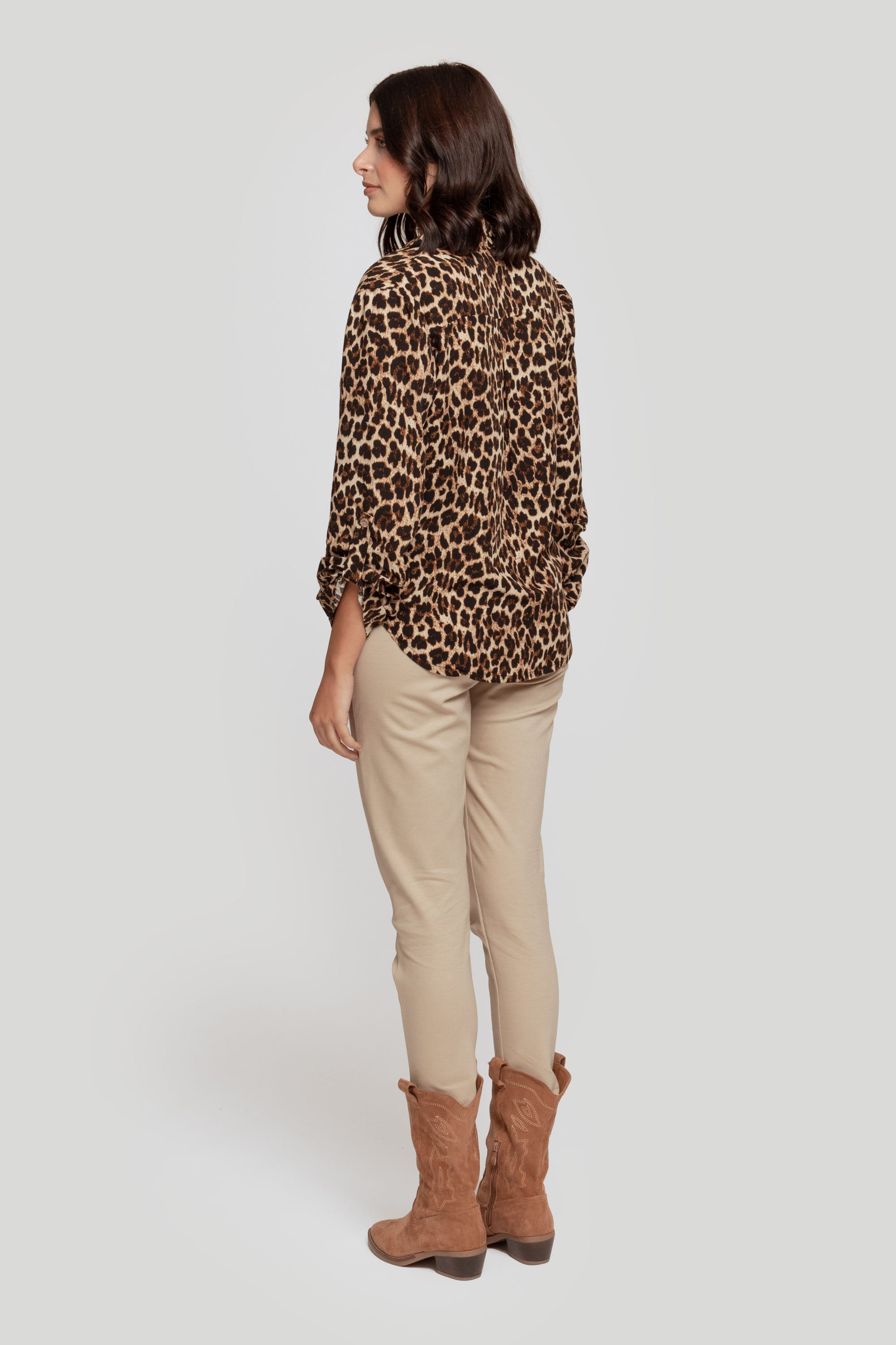 Femme vue de dos avec un pantalon fluide taille haute en viscose stretch, habillée d'une chemise léopard.