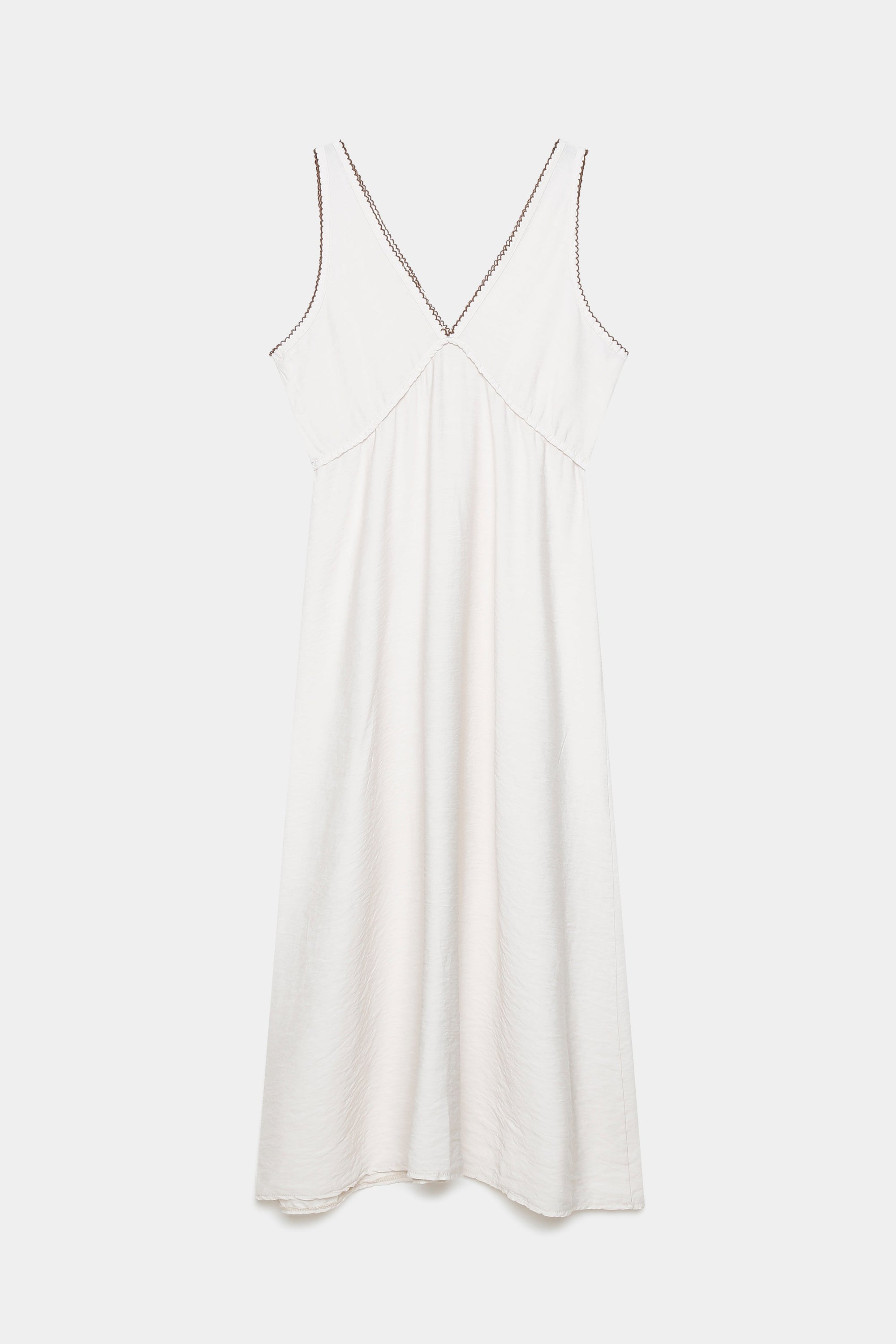 Robe midi fluide brodée en viscose confortable, présentée à plat, couleur blanche, avec des broderies délicates.