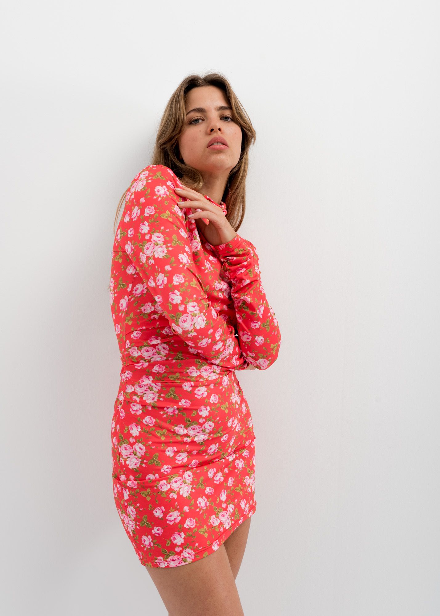 Gros plan sur une femme avec une robe fluide élégante imprimé floral rouge, mini robe moulante, capturant une ambiance féminine et séduisante.