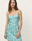 Minivestido de satén con estampado floral turquesa, ideal para el verano. Tirantes ajustables y espalda abierta.